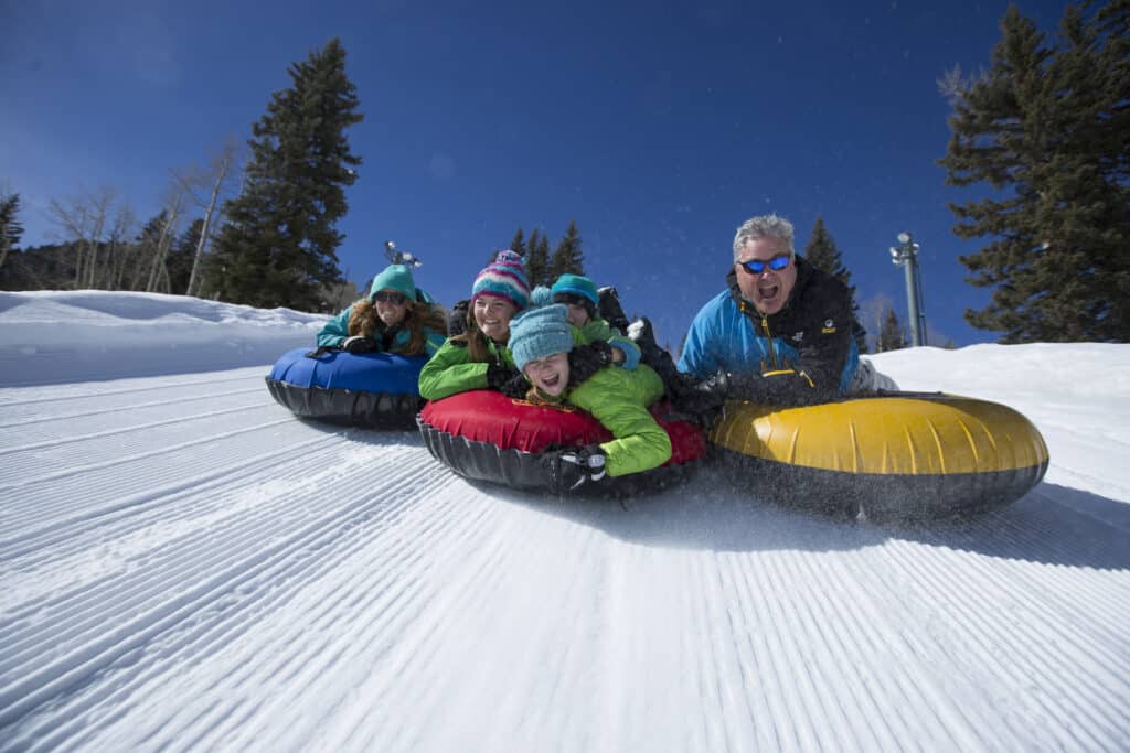 A family races down the tubing hill at Purgatory Resort.