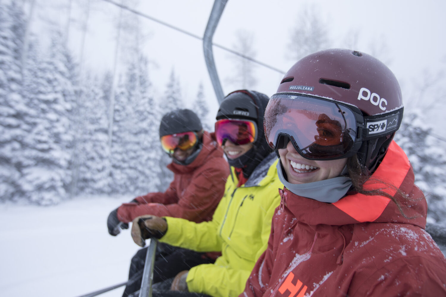 people smiling on lift on a powder day