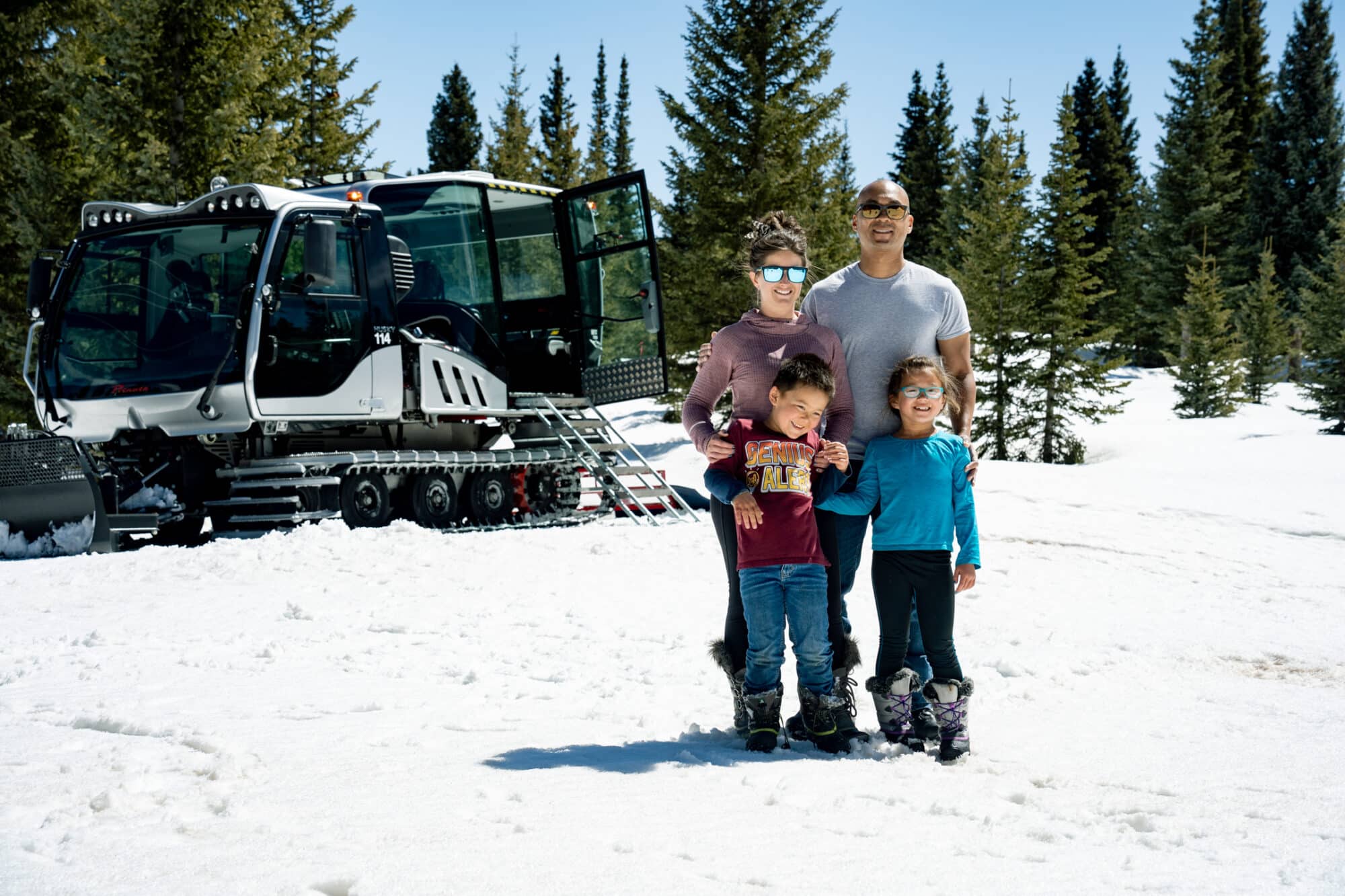 Family poses in front of the new scenic snowcat