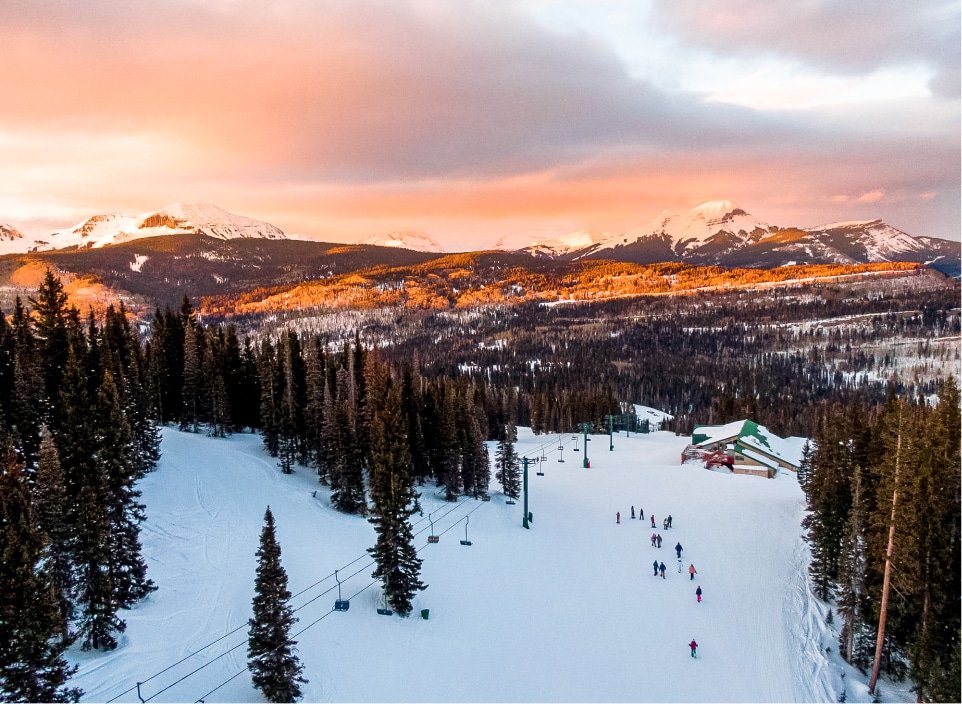 A group enjoys a snowshoe tour at sunset