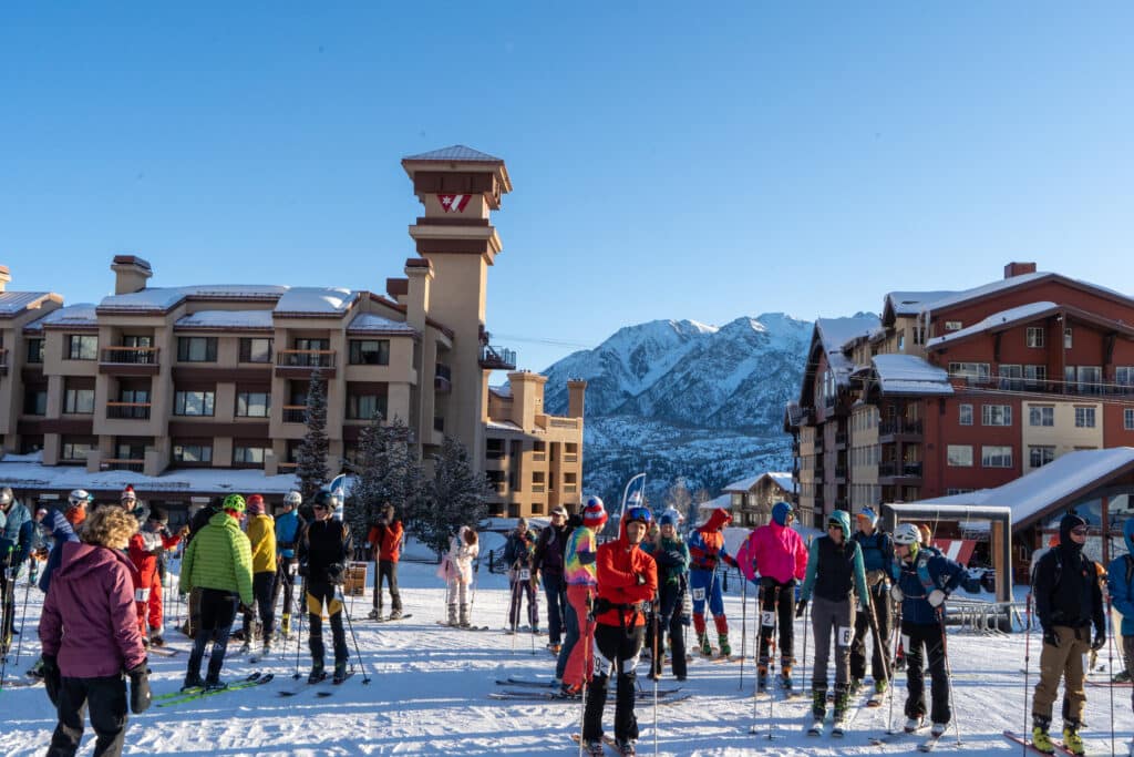 skiers mingle and wait for friends at the base of the mountain