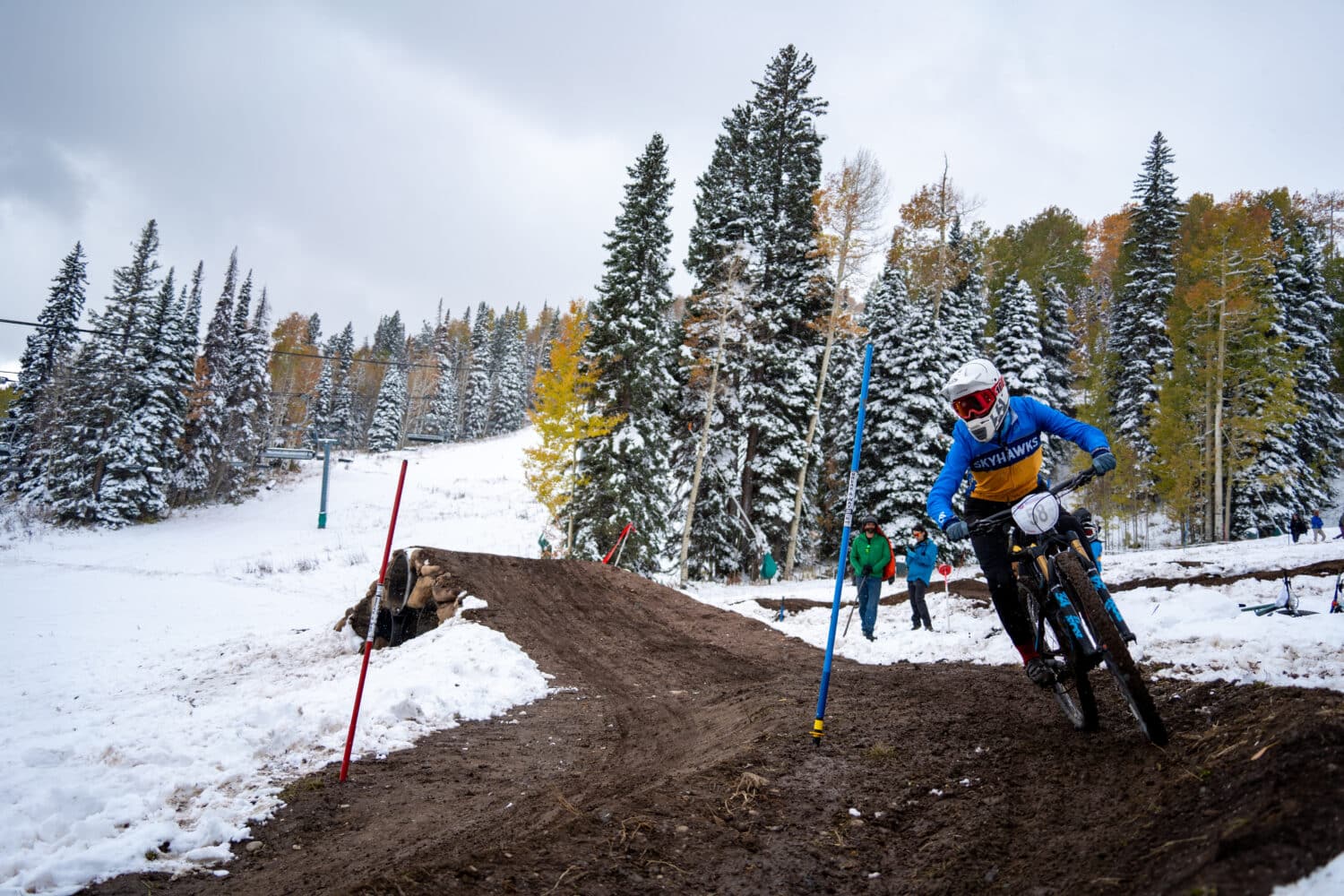 Fort Lewis College collegiate athlete races down the dual slalom course as a fresh blanket of snow covers the fall colored aspens