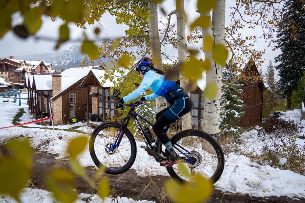 Fort Lewis College collegiate athlete races down the jump line towards the finish line captured through the color changing aspens.