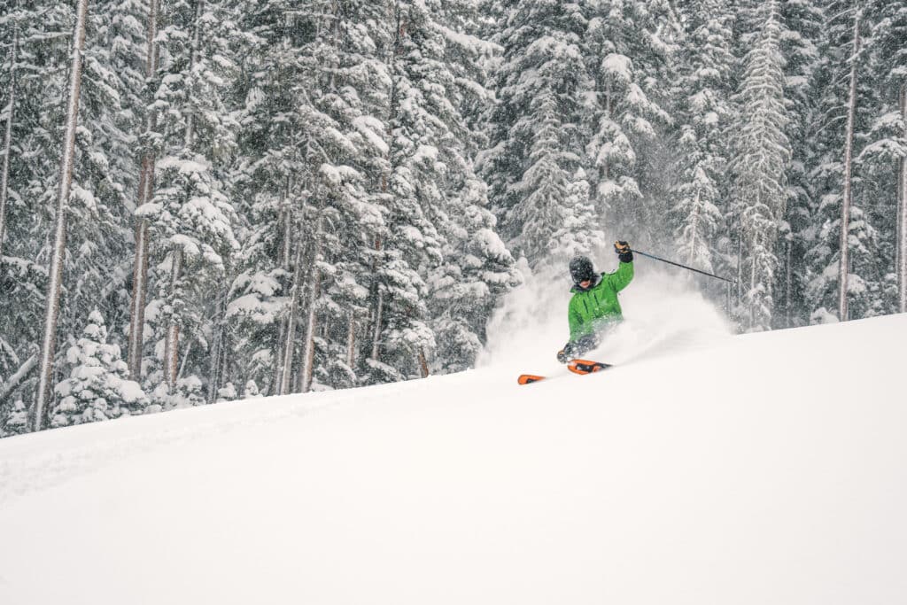 Skier take powder turn on a wide open trail