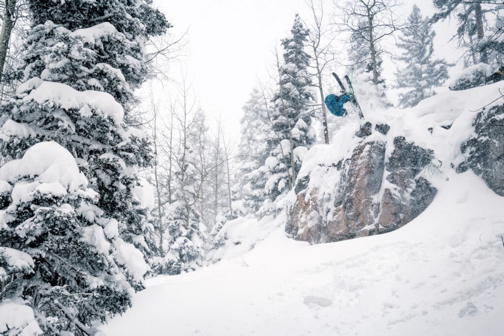 powder skiing off a cliff