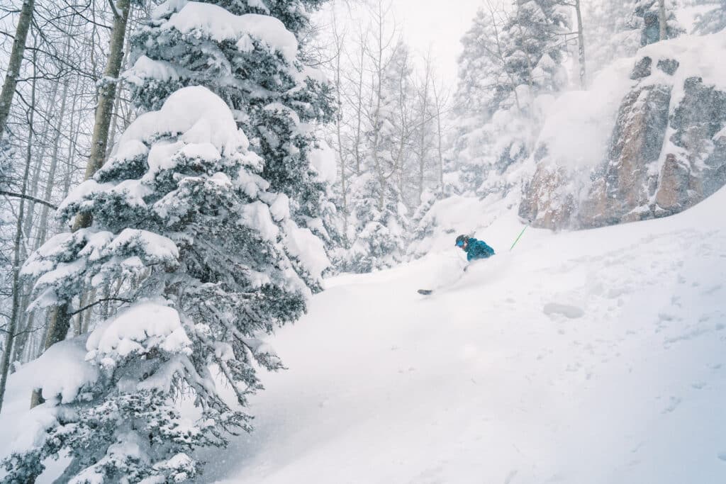 powder skiing off a cliff