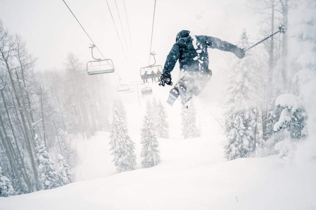 Skier dropping cliff on a powder day