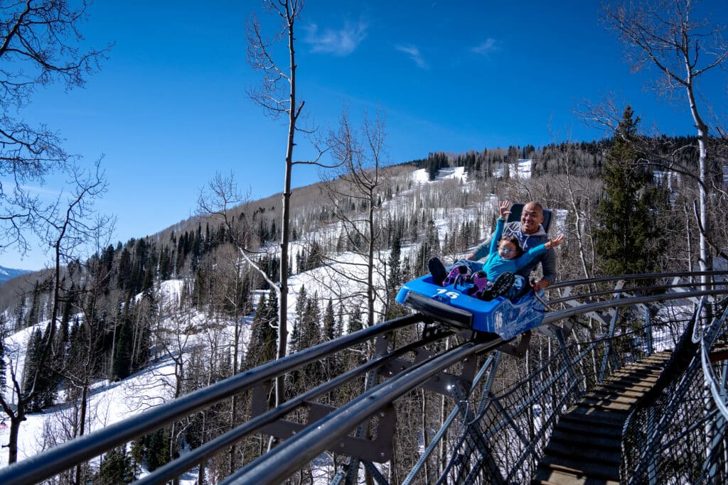 A father and daughter ride the mountain coaster