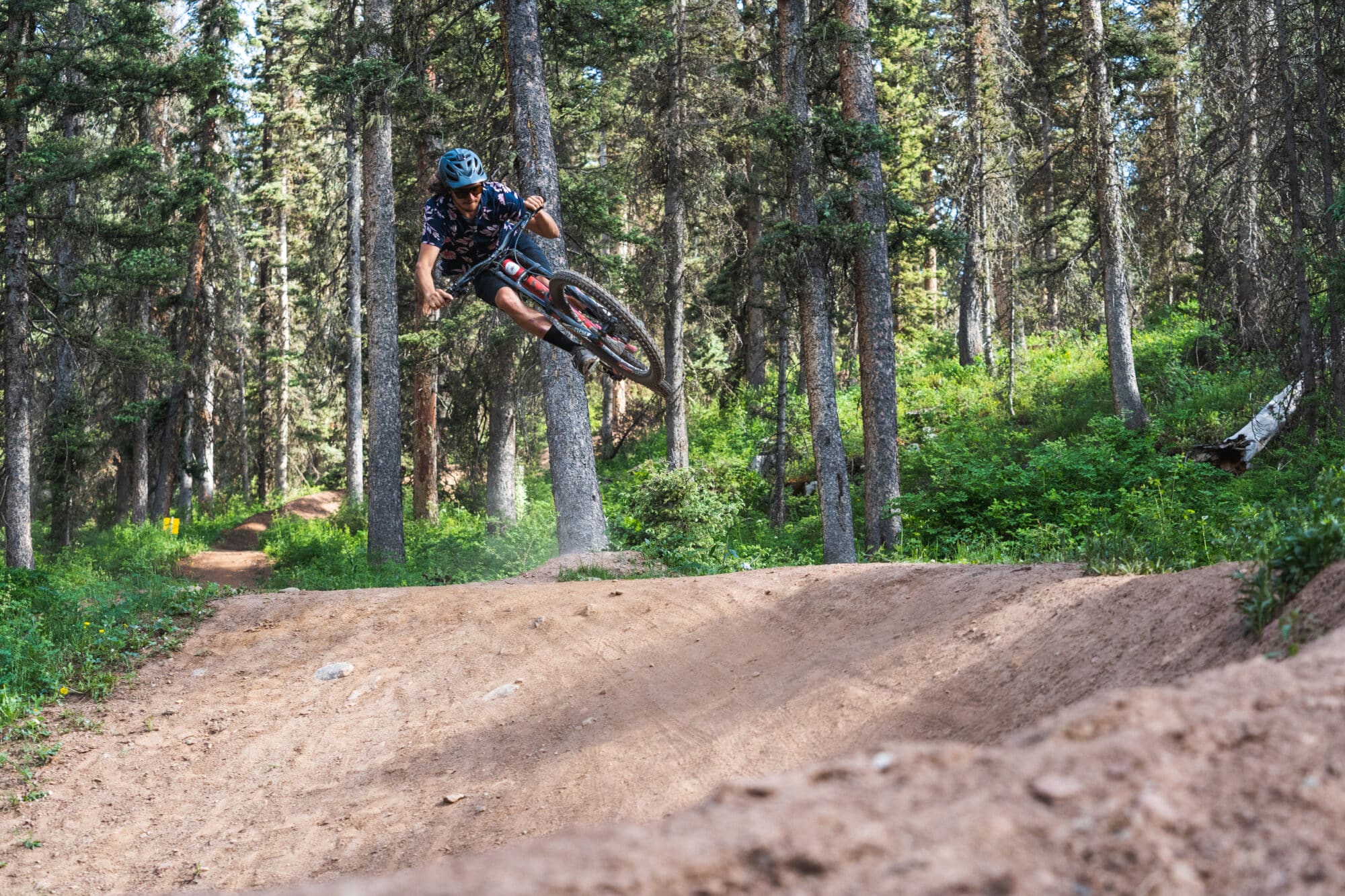 Mountain biker catches huge air while riding down the Divinity flow trail