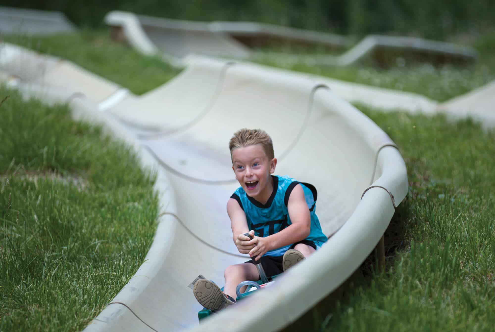 Young kid having an absolute blast on the alpine slide