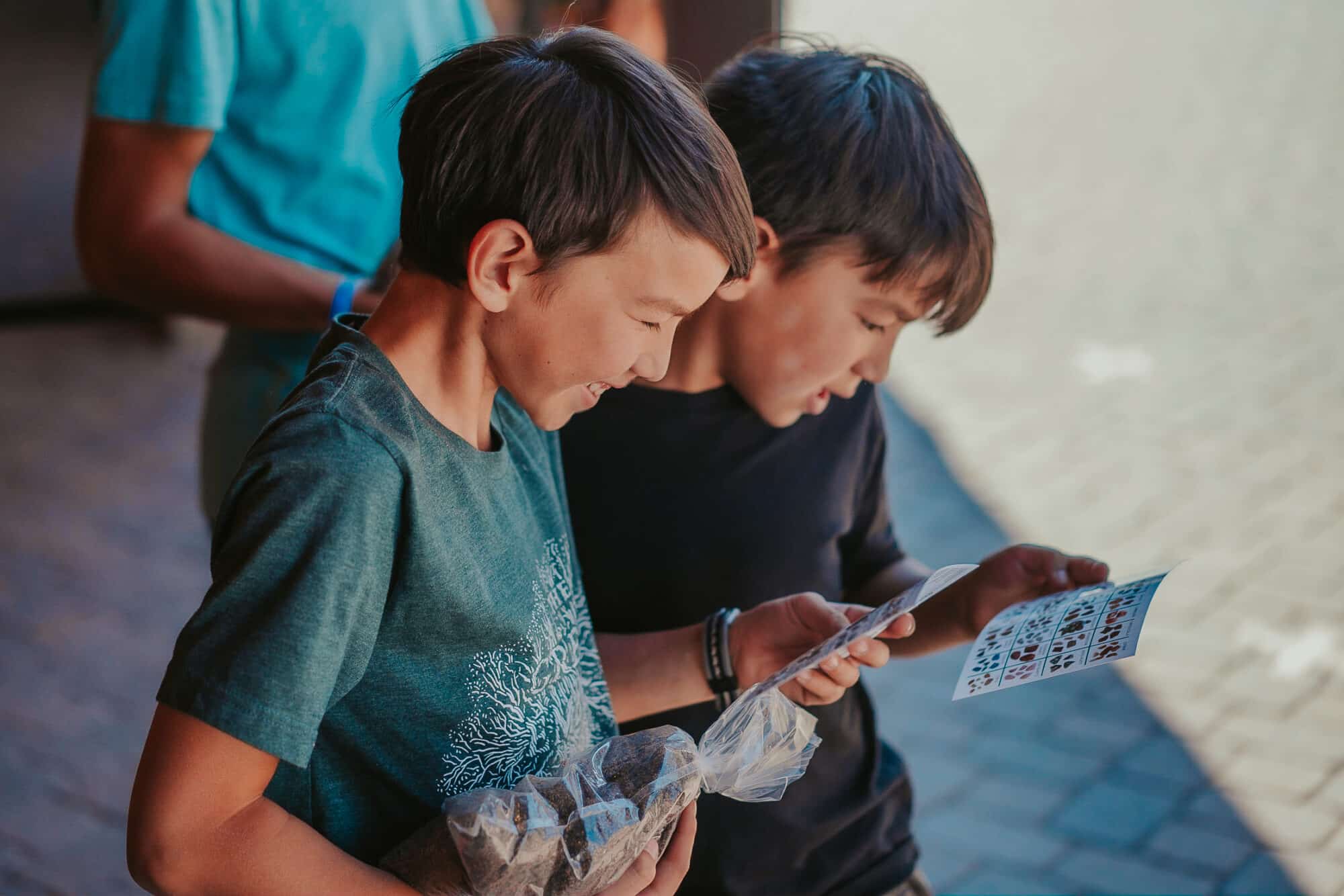 Brothers look over the gemstones and other treasures they could find in their treasure panning bags