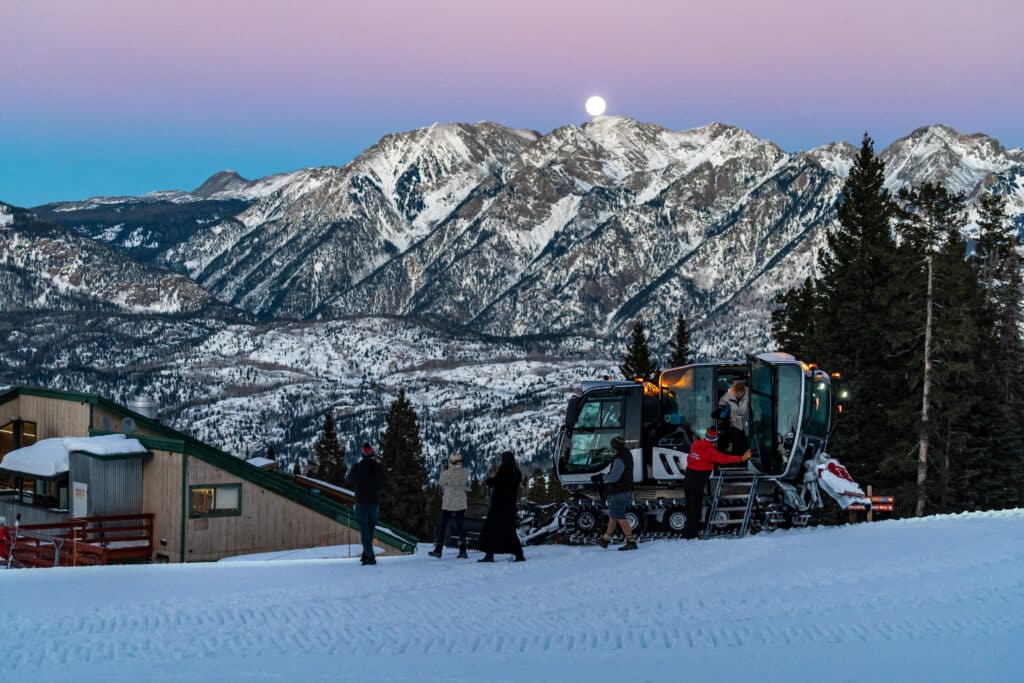 People exiting snowcat ready to enjoy dinner