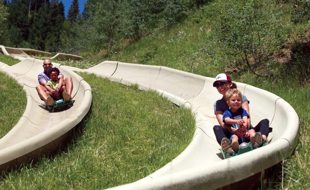 A family enjoys the alpine slide