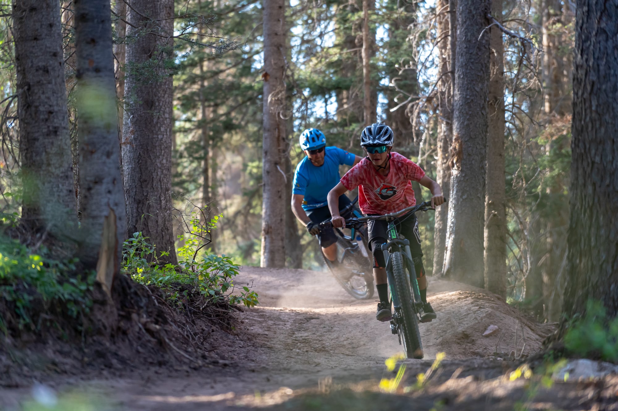 Father and son round a corner turn mountain biking