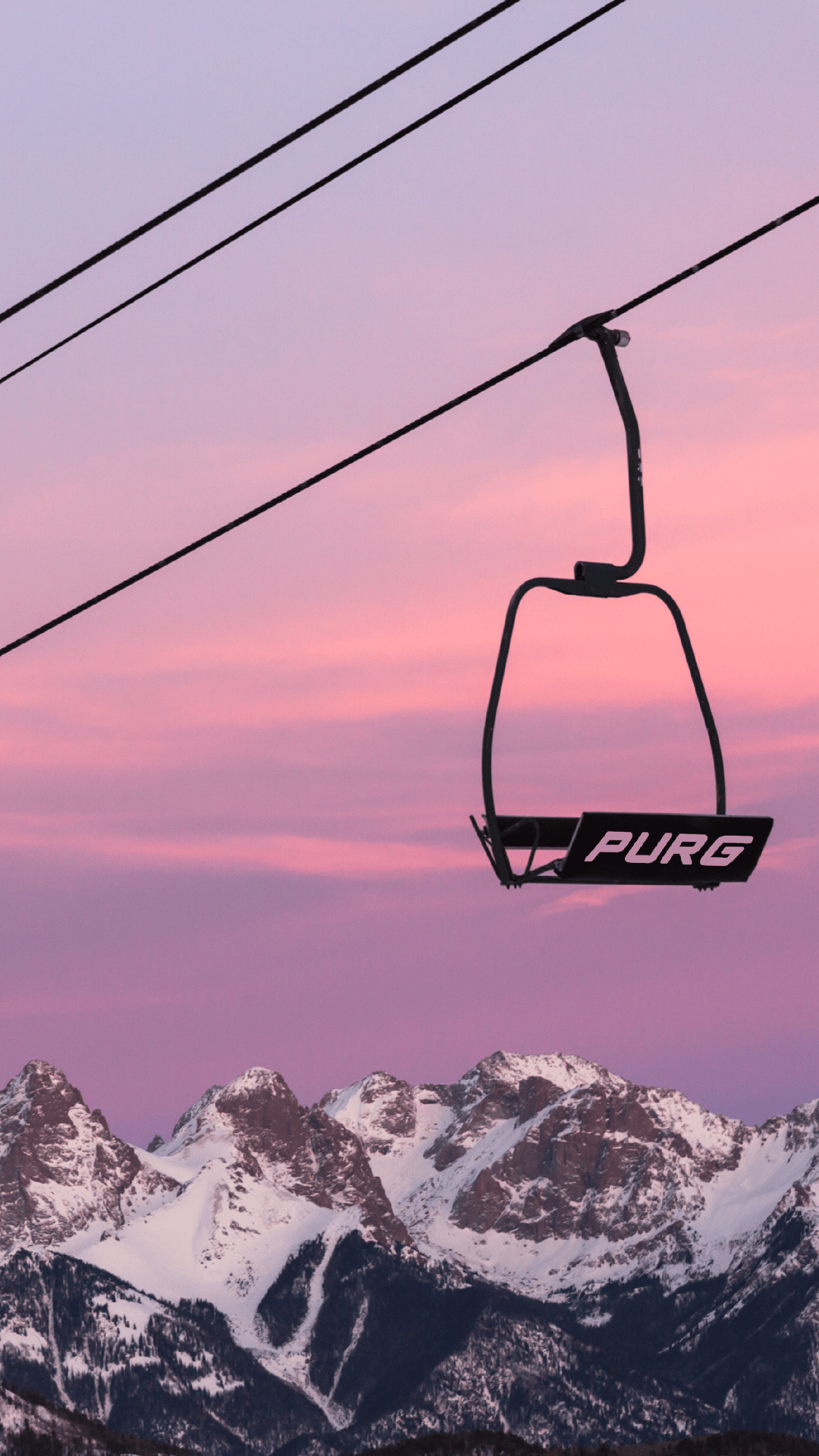A chairlift hangs against a mountain winter backdrop