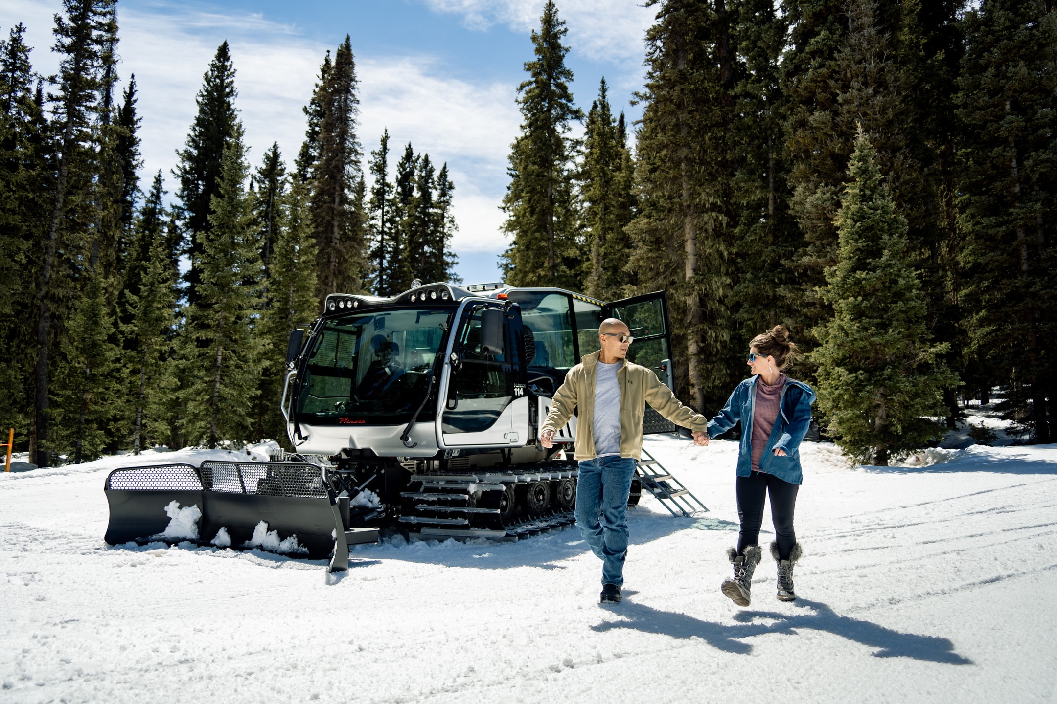 Couple happily walking away from the scenic snowcat after a great tour