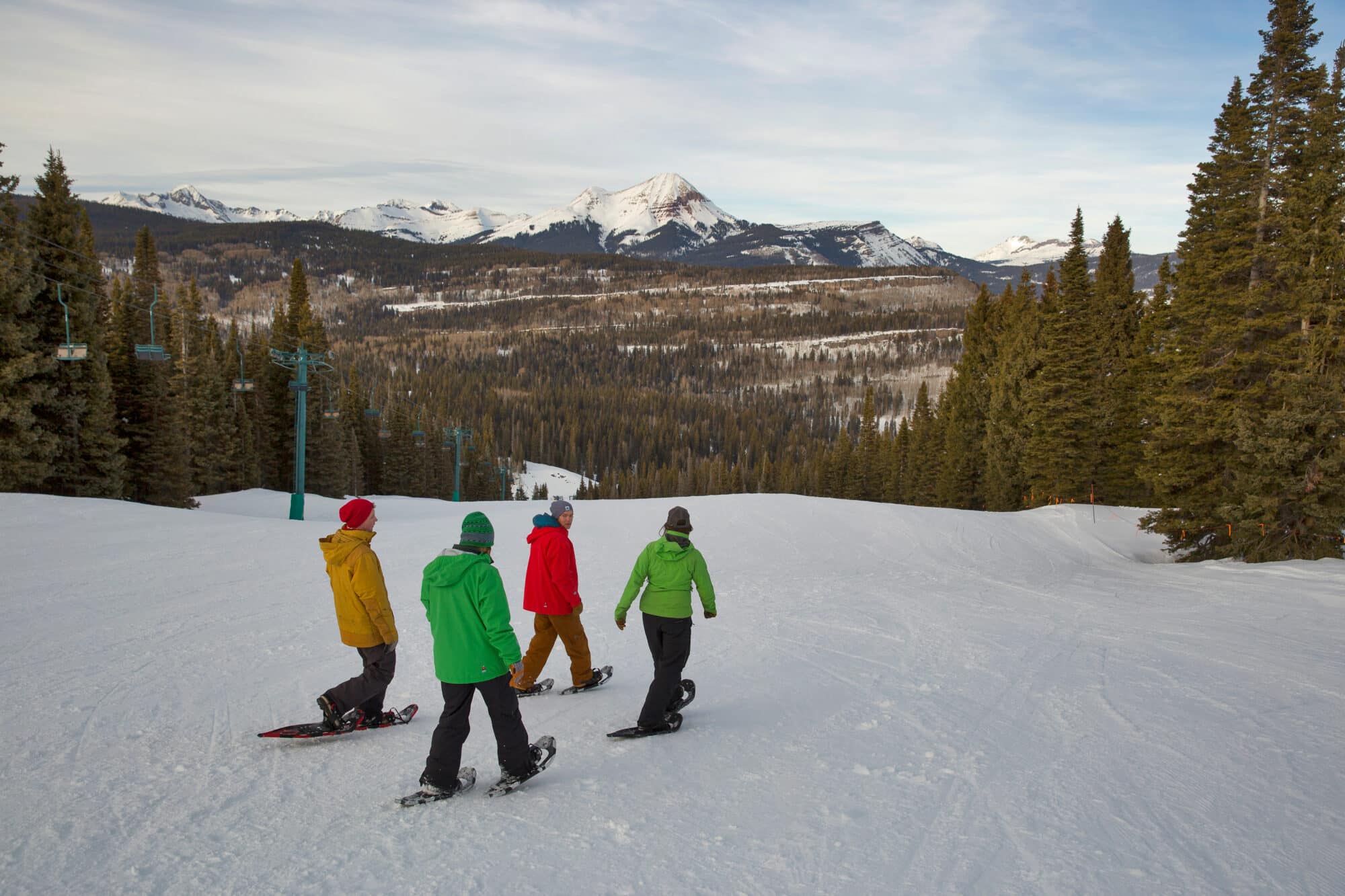 Group of snowshoers make their way down the mountain as they take in the beauty of Engineer Mountain