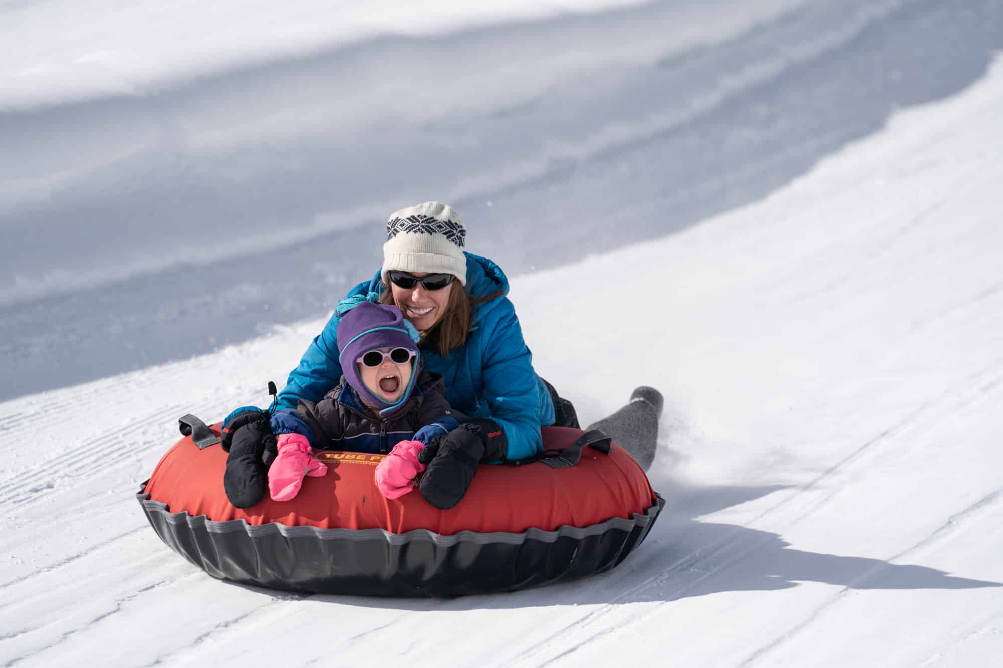 Mom and daughter enjoying the thrill of sliding down the tubing hill