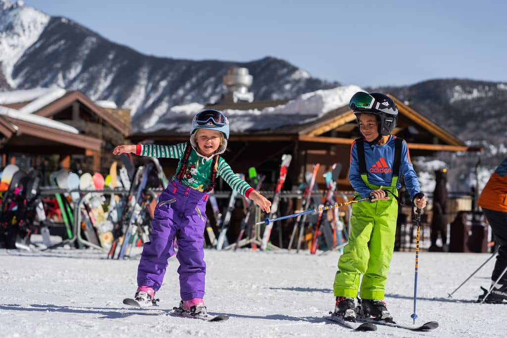 Young kids on skis make their way toward the lift