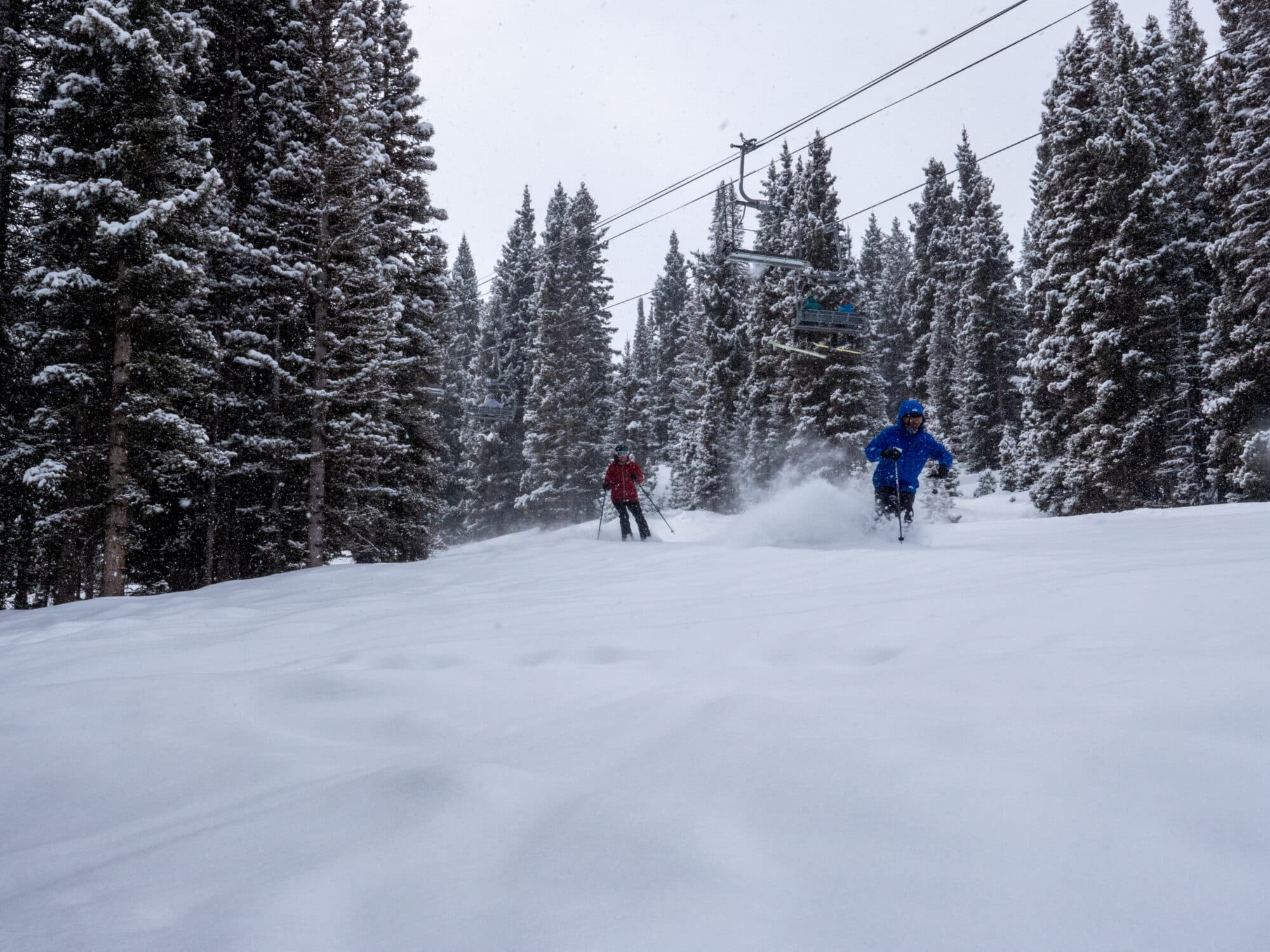 Women's ski clinic groups follows instructor through deep powder