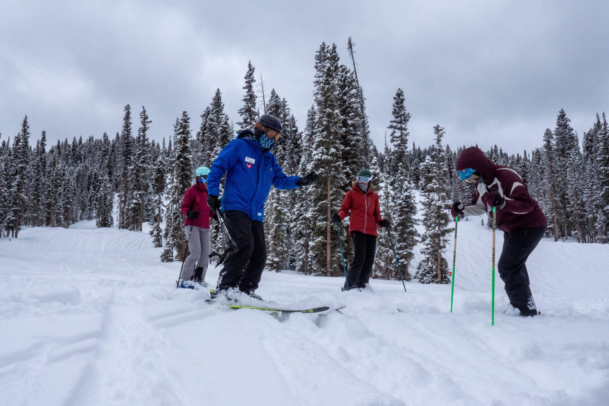 Women's group being taught how to make powder turns on a snowy cold day