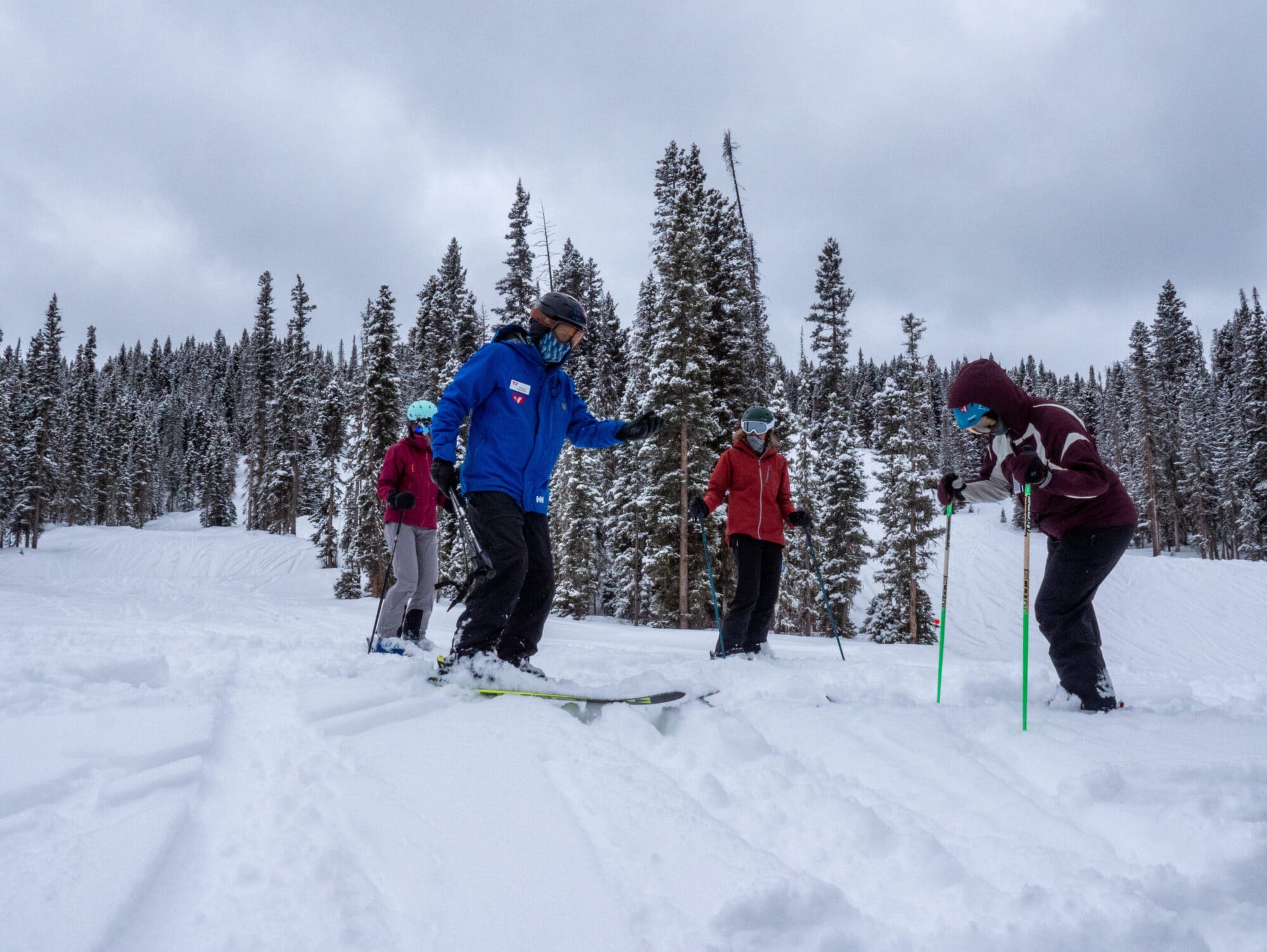 Women's group being taught how to make powder turns on a snowy cold day