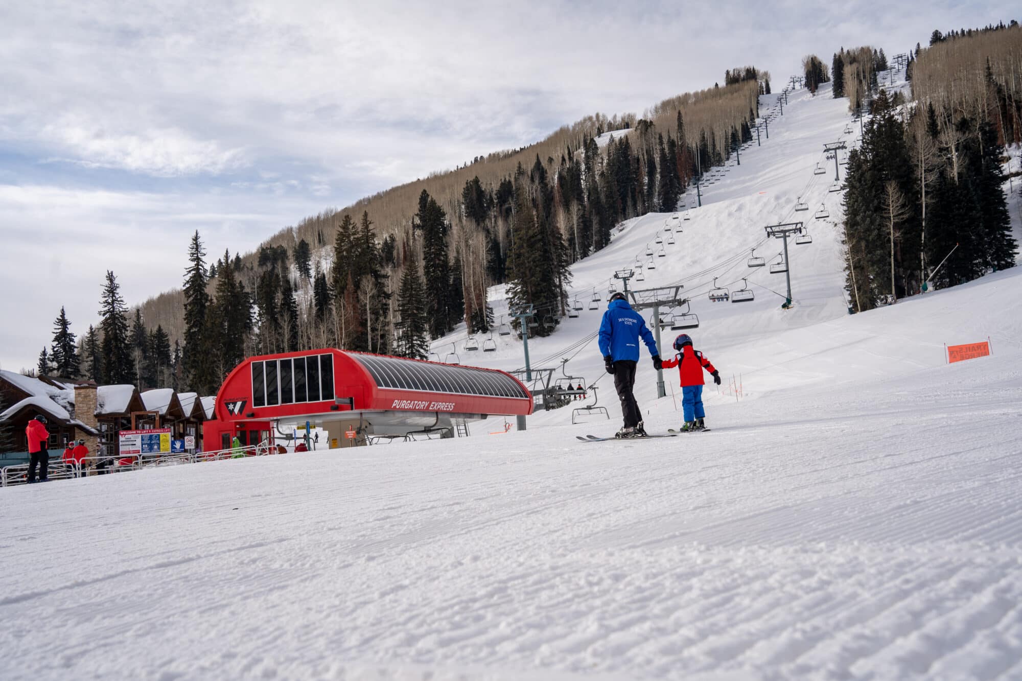 Ski Instructor helps young student to lift during a private lesson