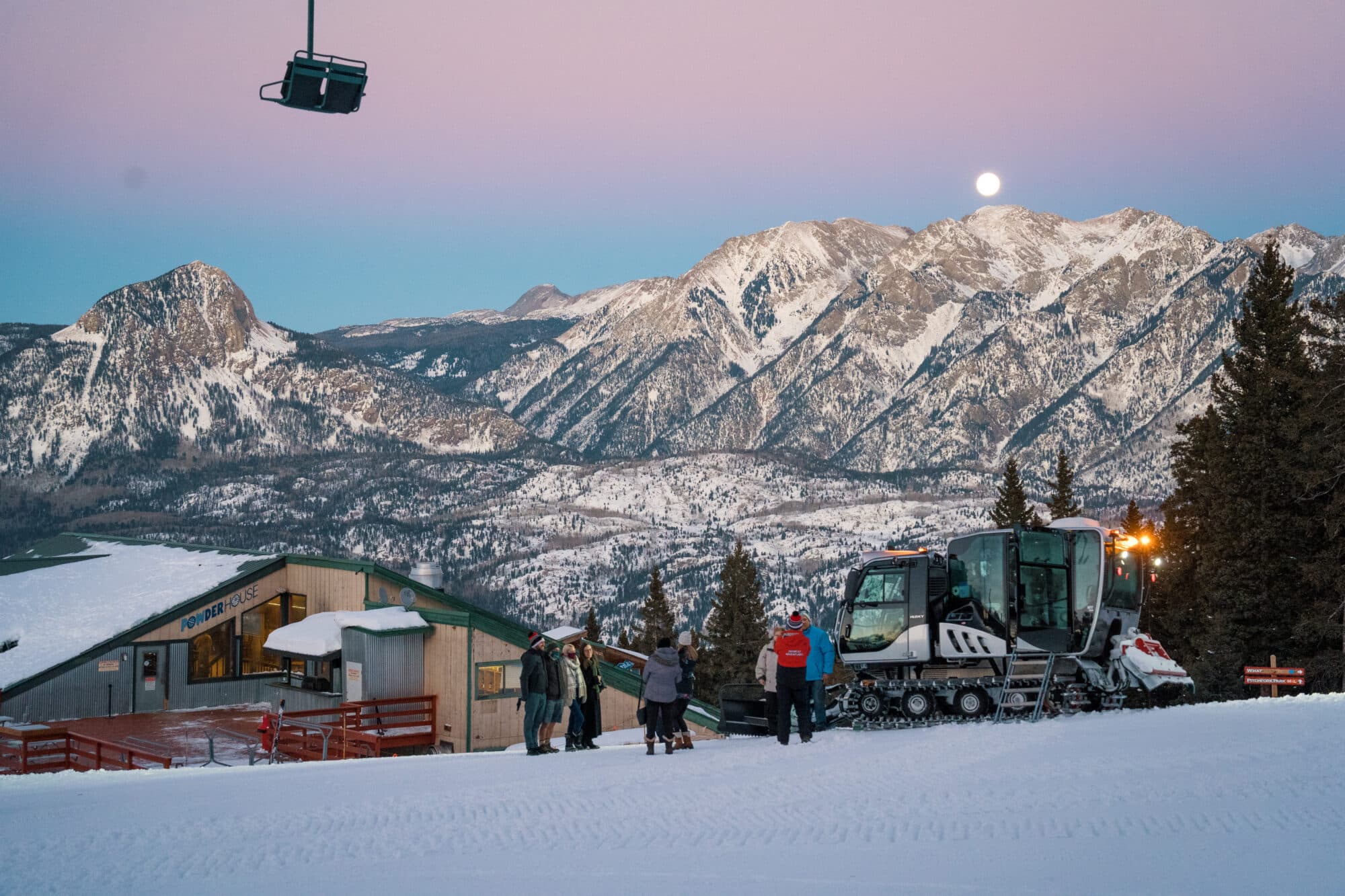 Guests take photos of the beautiful sunset outside of snowcat