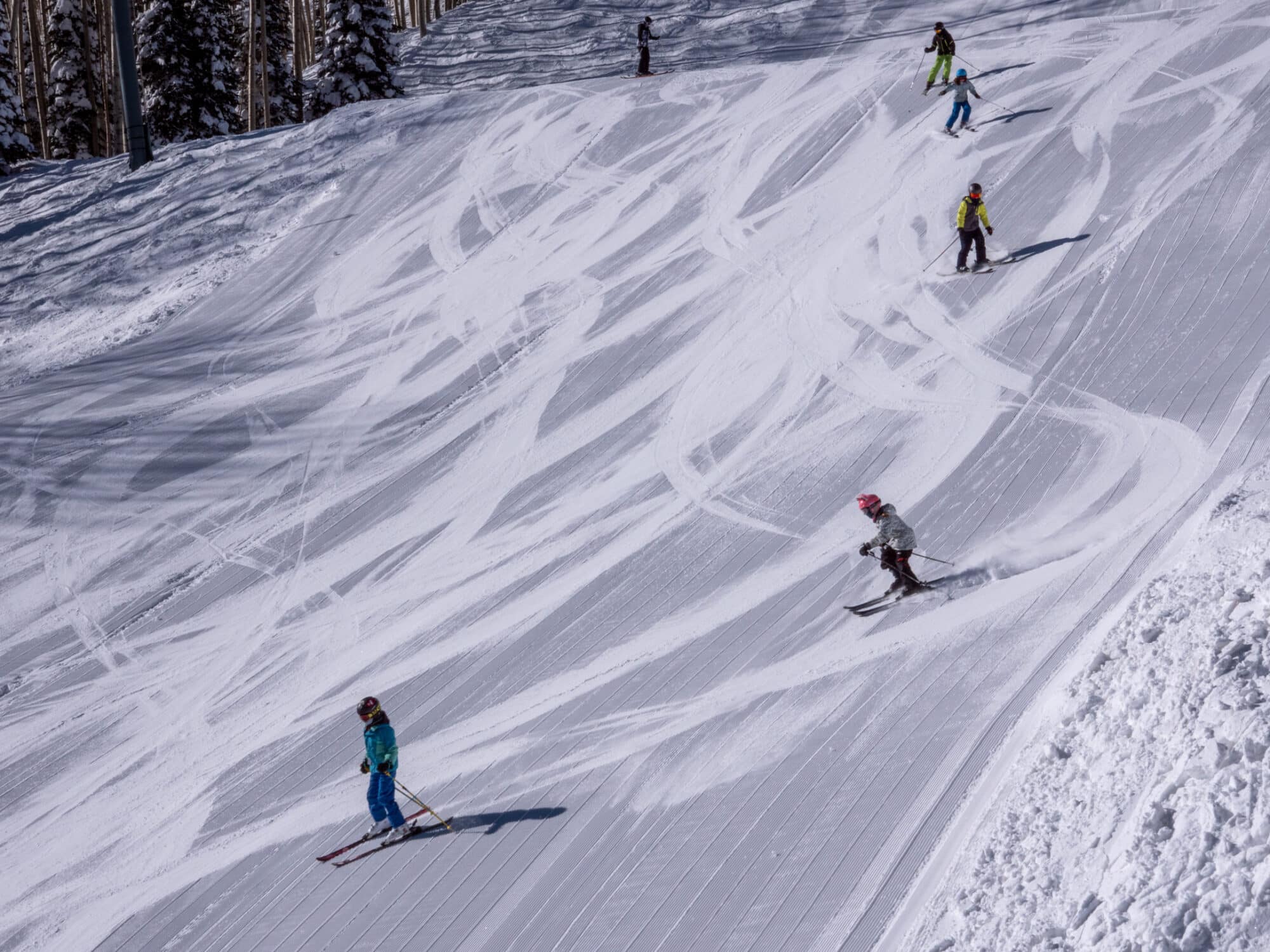 Group of kids ride down the mountain in a line