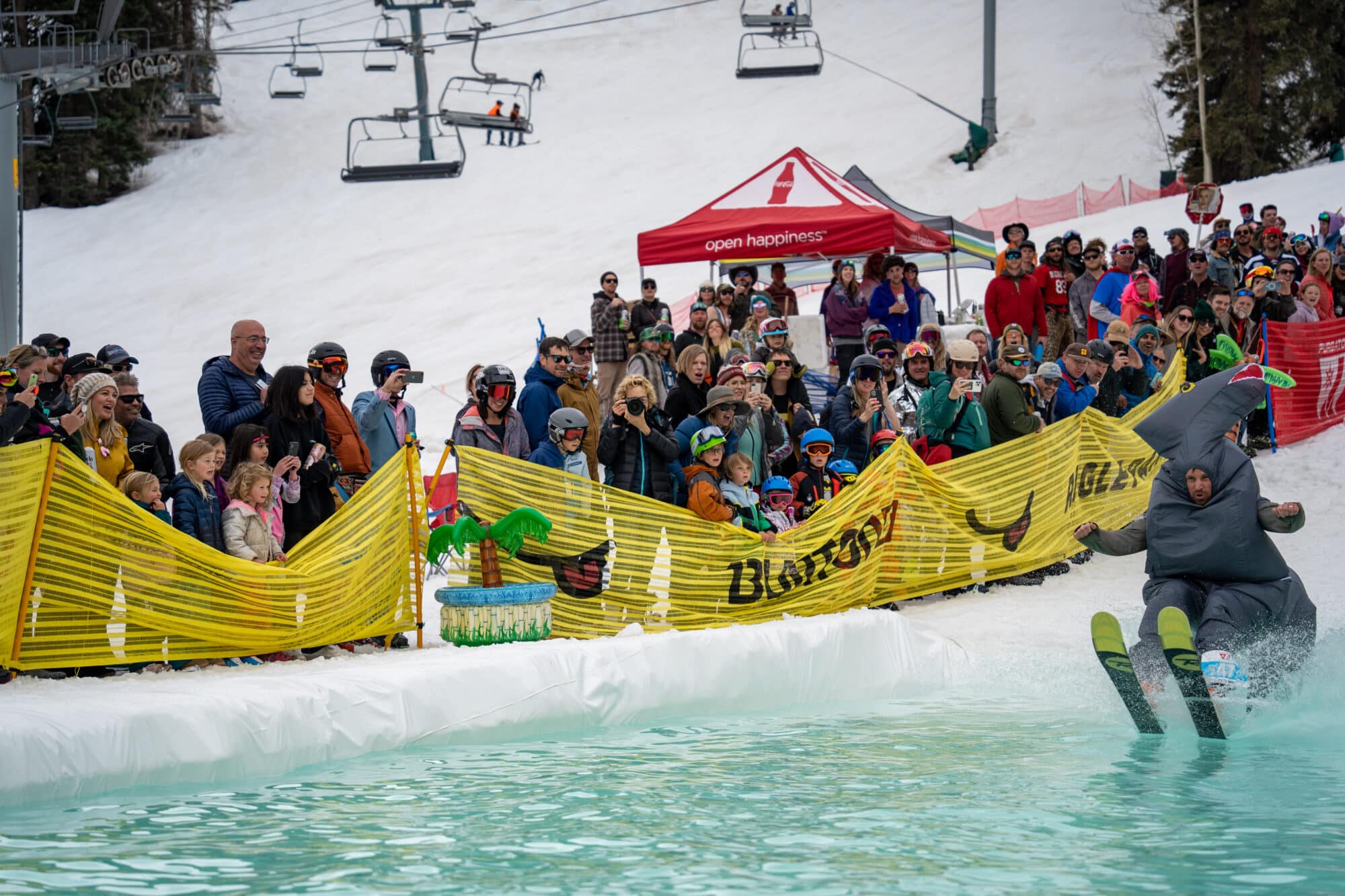 Skiers in a dinosaur costume glides across the pond skim