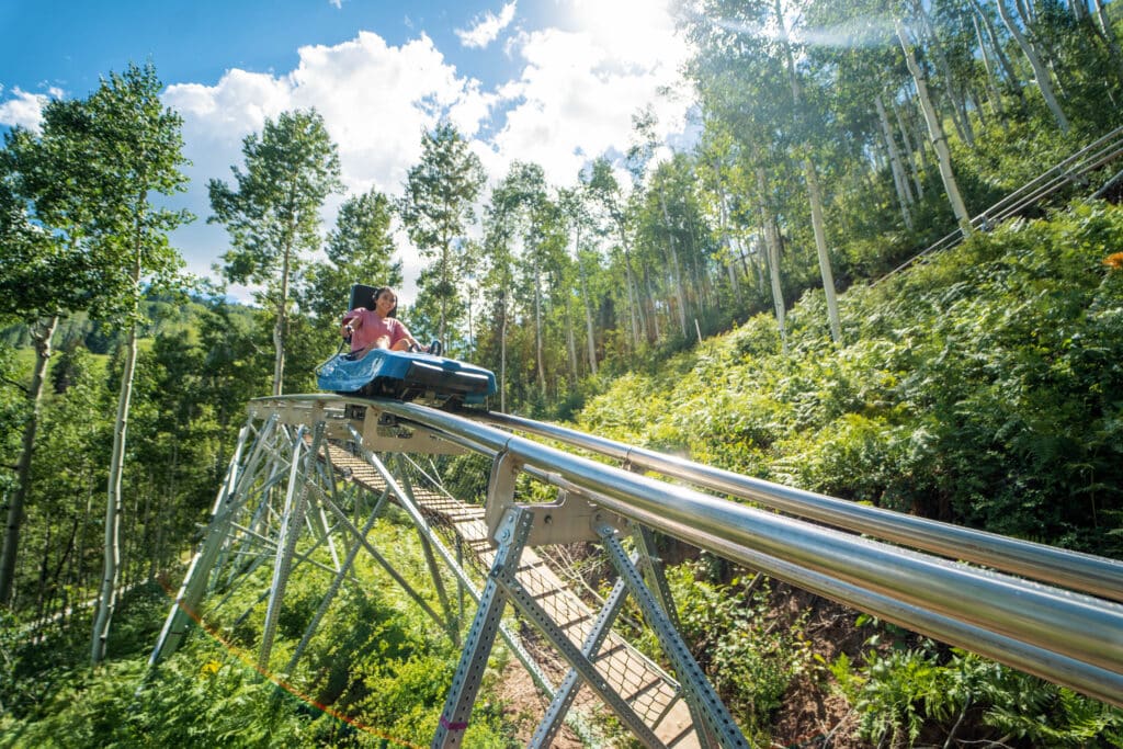 Girl riding the mountain coaster during summer