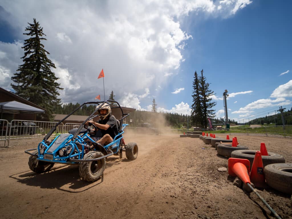 Rider races down the straight away in a blue go kart 