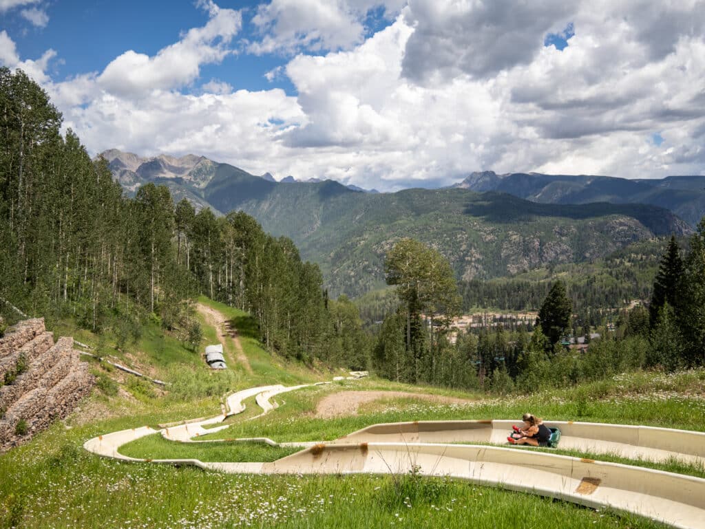 Rider gains speed down the alpine slide as it snakes down the mountain