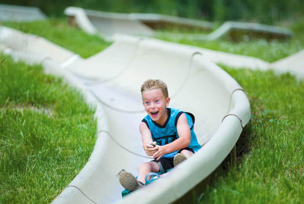 Young kid having an absolute blast on the alpine slide