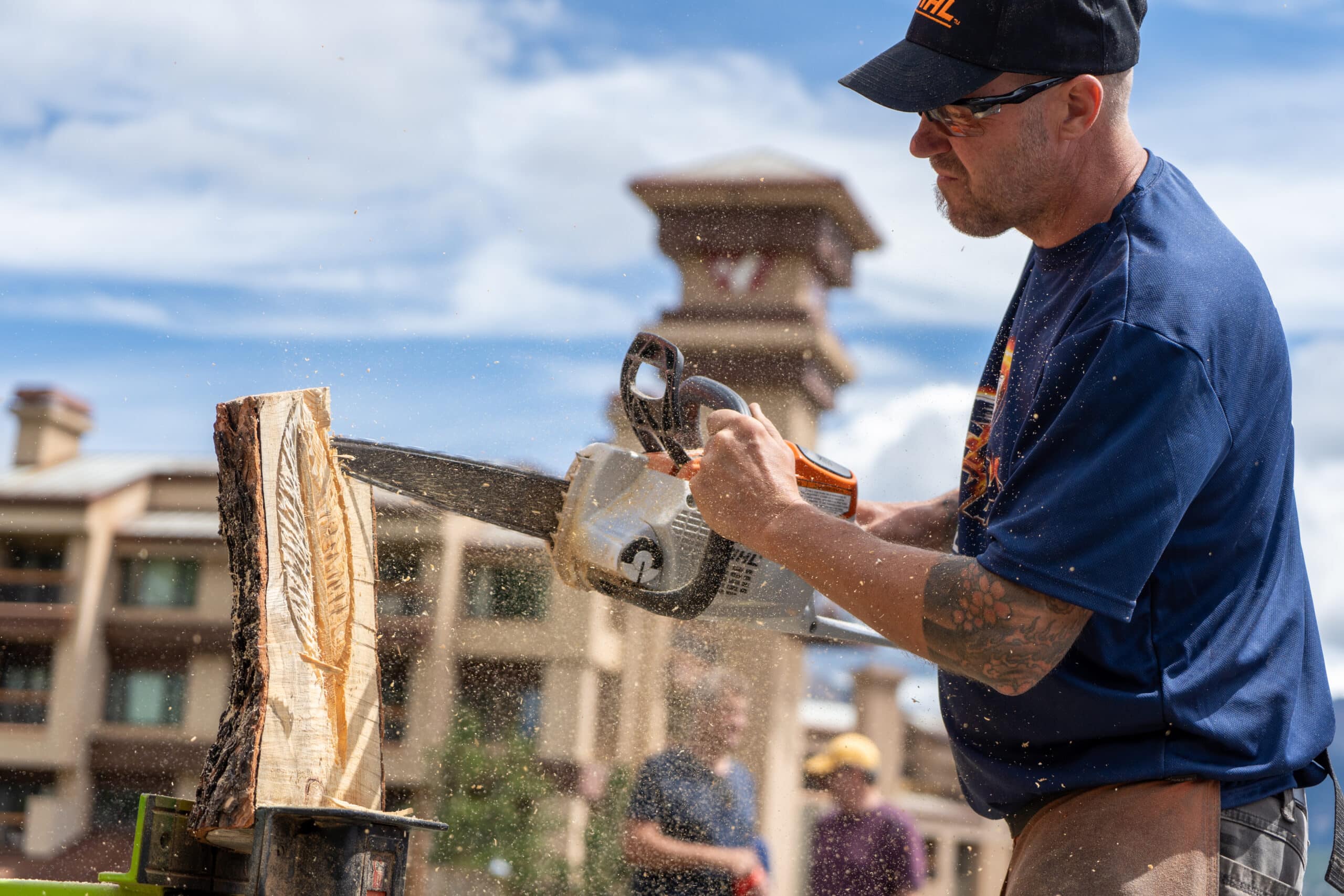 Artist carves a pieces a wood using a chainsaw at Purgatory's annual Carve Wars 