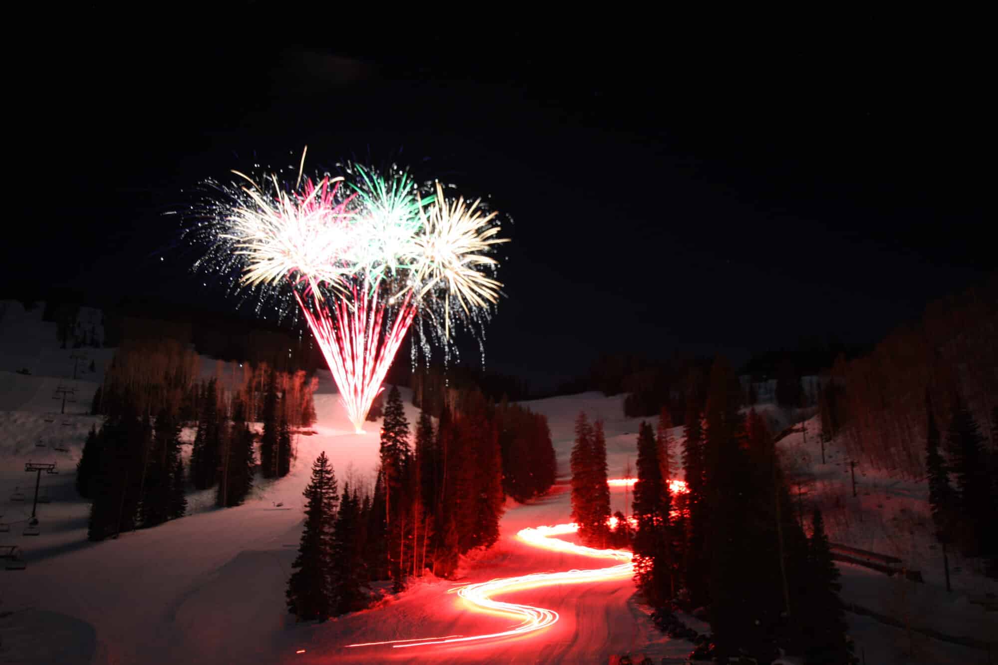 Torchlight parade winds down the mountain as fireworks light up the sky