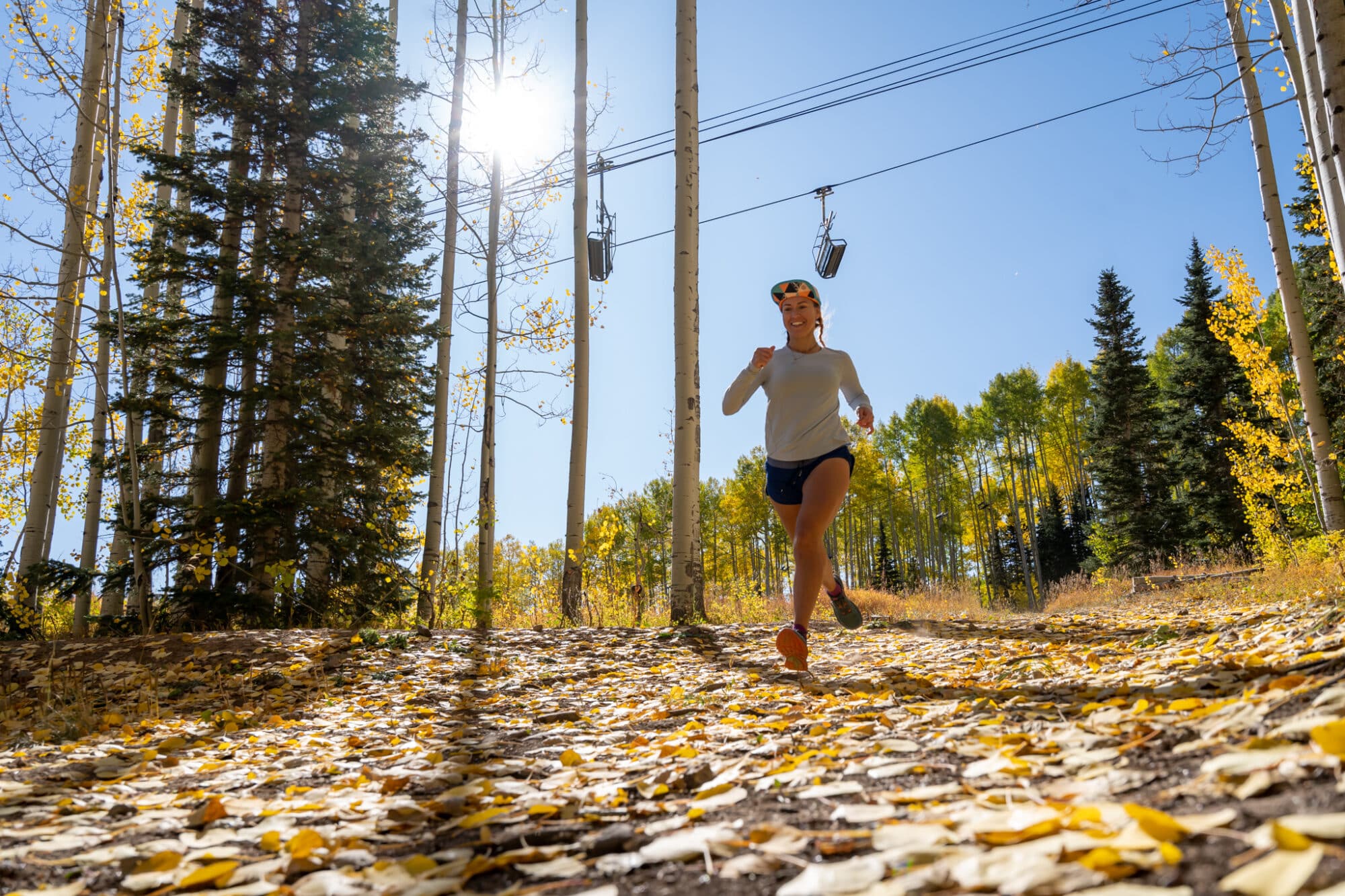 Trail runner runs underneath Purgatory Express lift during fall