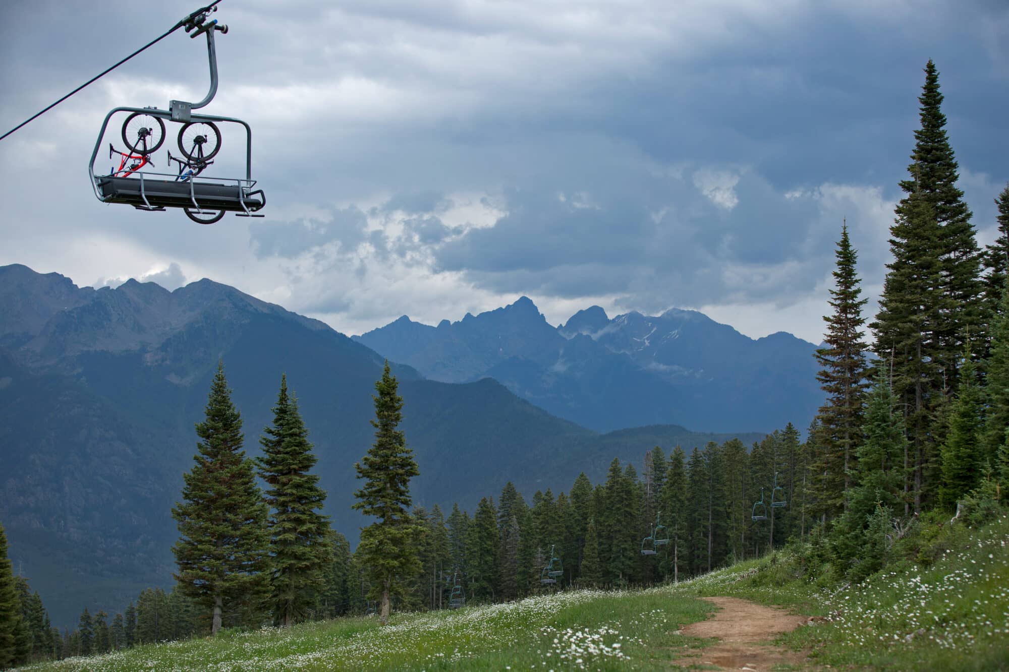 Mountain bikes hang on the mountain bike carrier hooks on the back of a chairlift