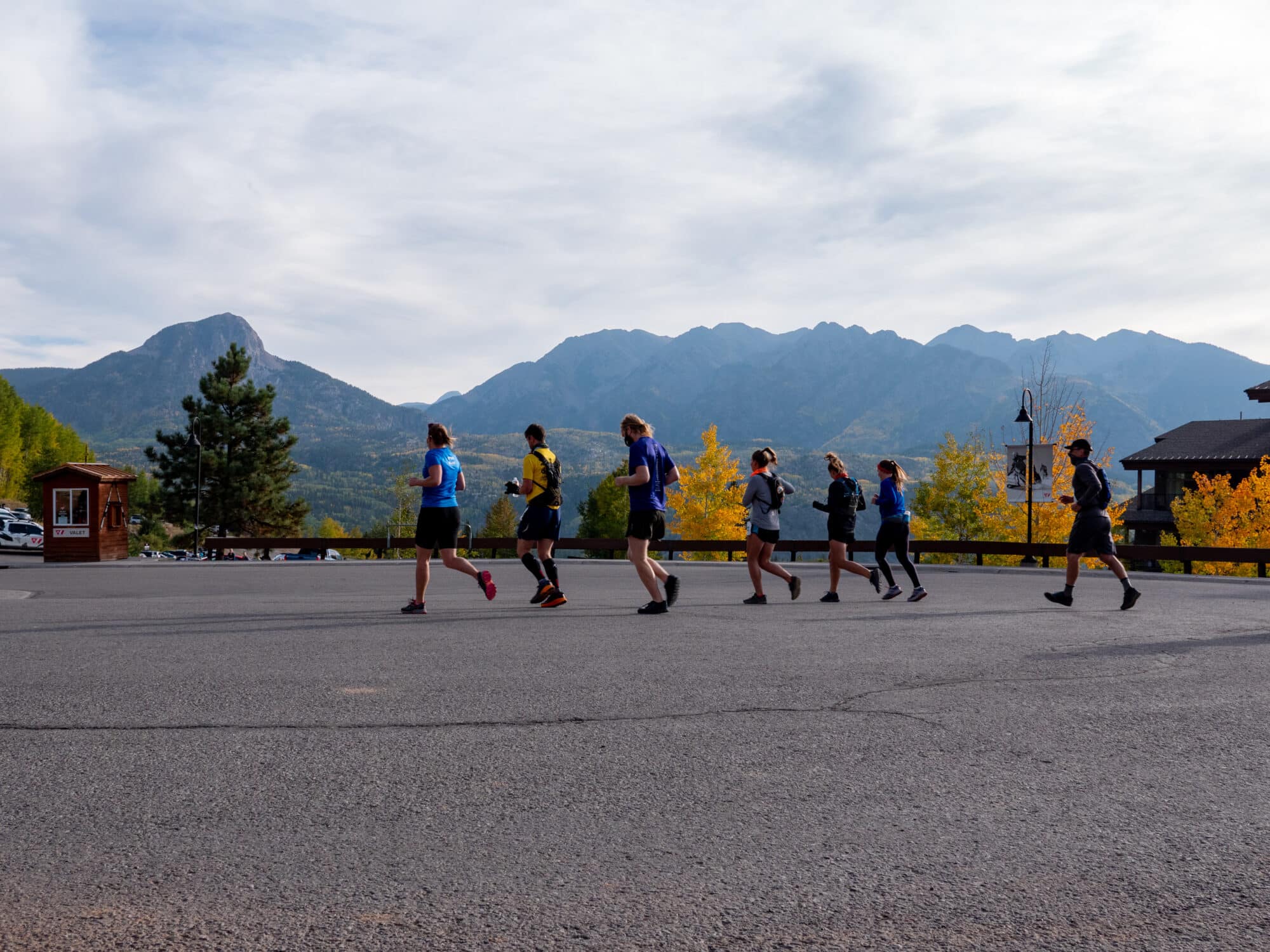 A pack of runners run through the arrival court to start the Mountain Marmot Trail Run
