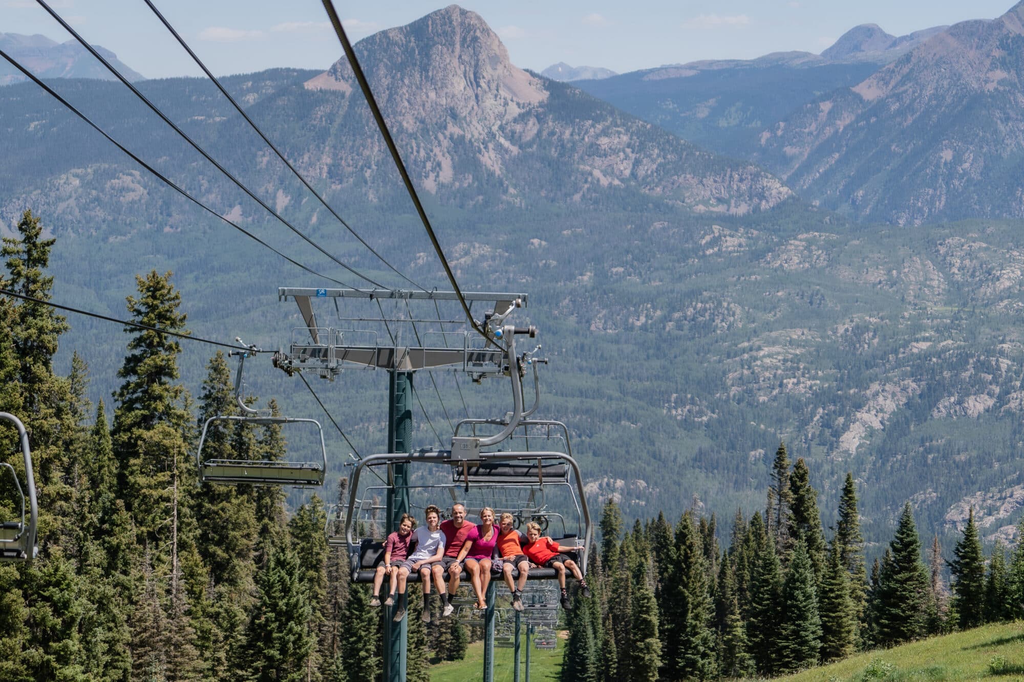 Family rides up the scenic chairlift with Potato Hill in the background