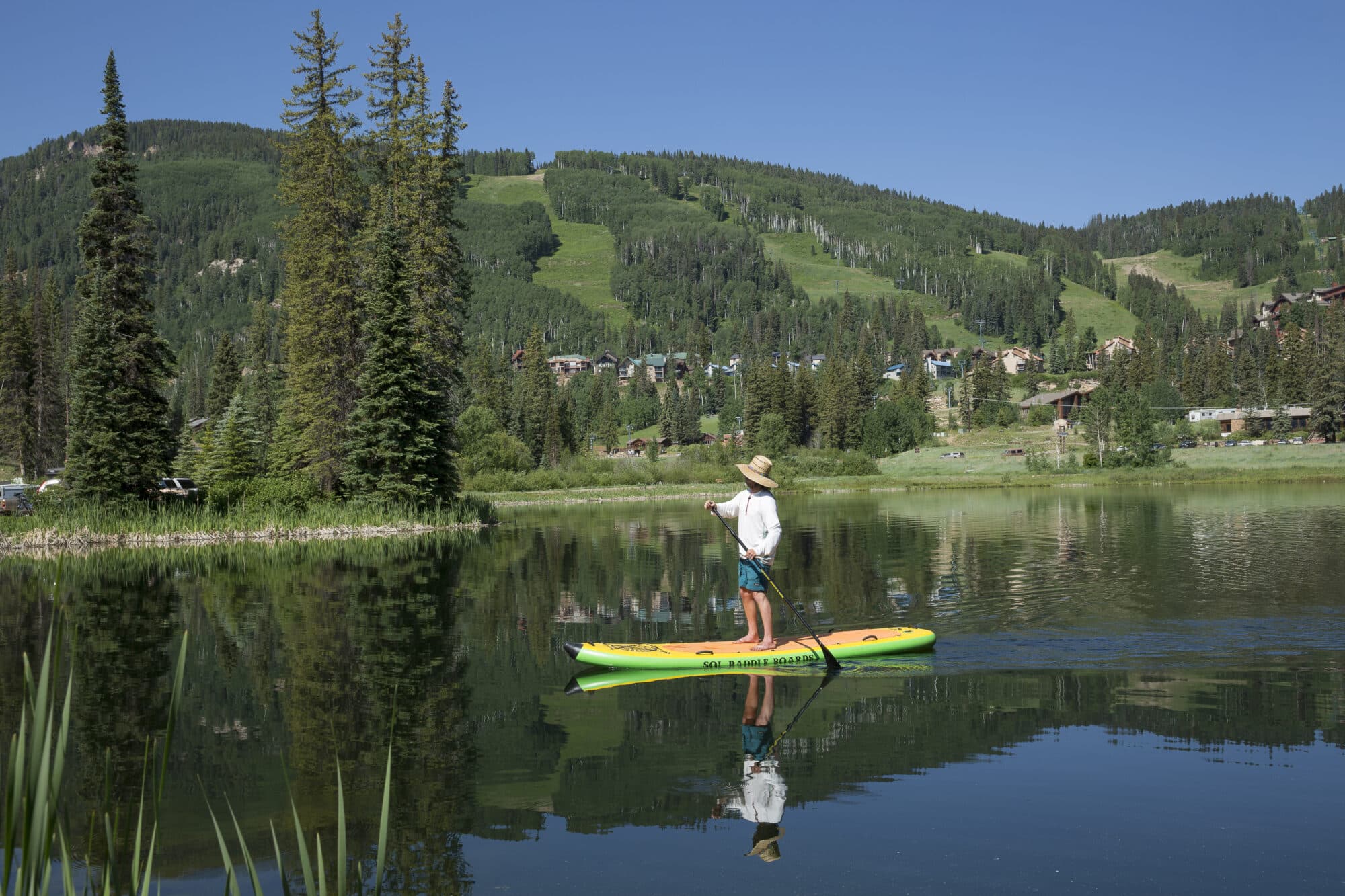 Paddle boarder glides across glassy waters at Twilight Lake