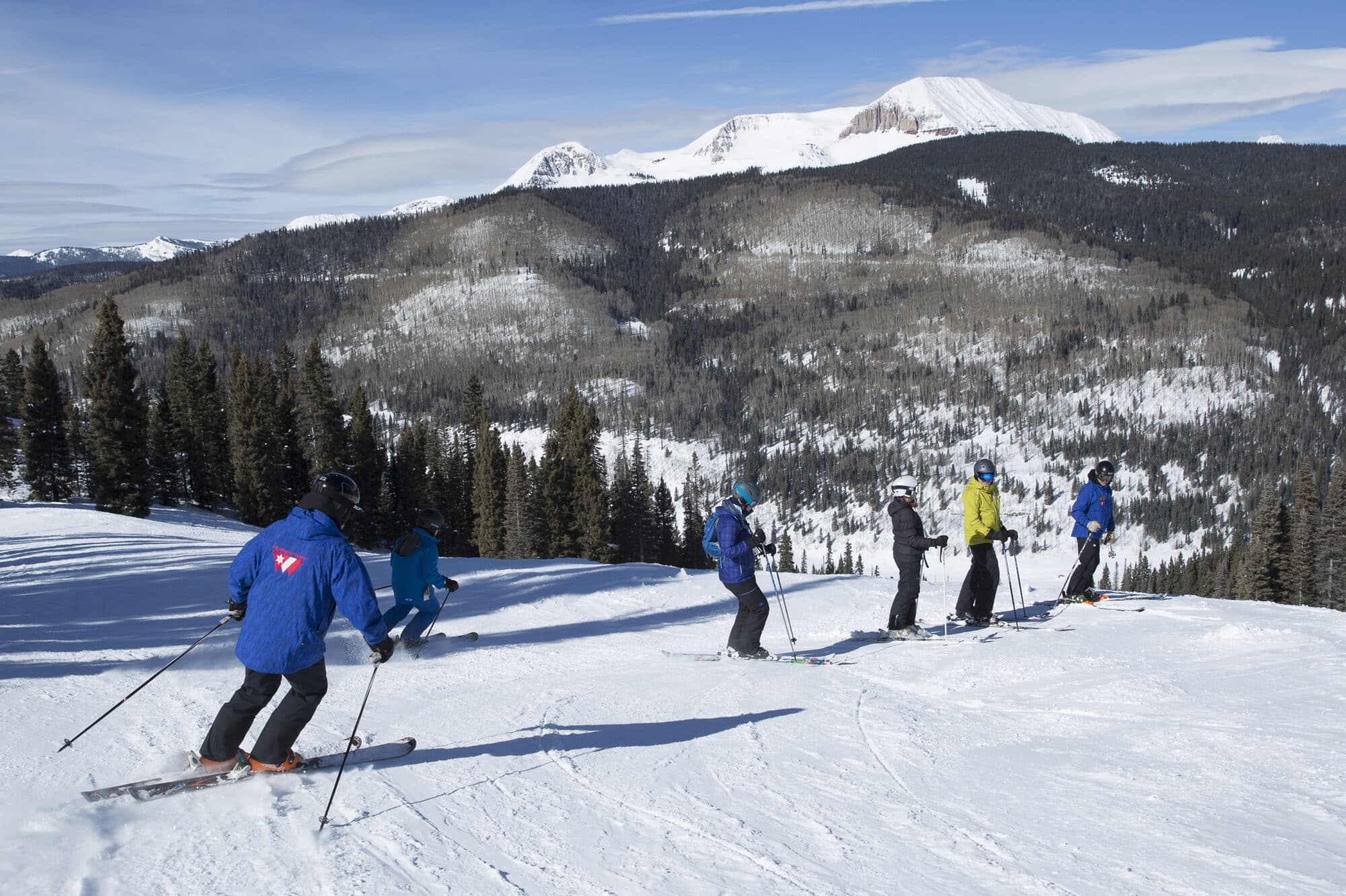 Adult group lesson stops mid mountain to gather the entire group