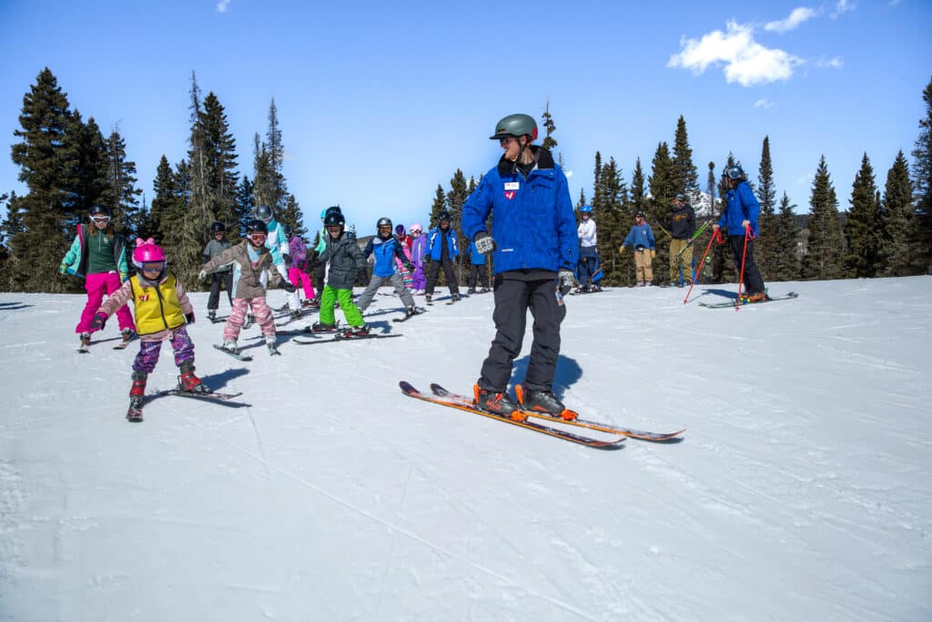 Instructor leads his kids group down the mountain