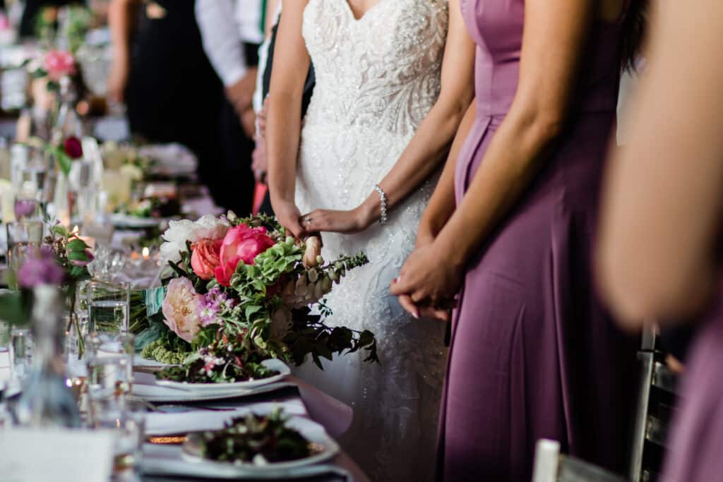 Bride and bridesmaids stand over a beautiful wedding table setting