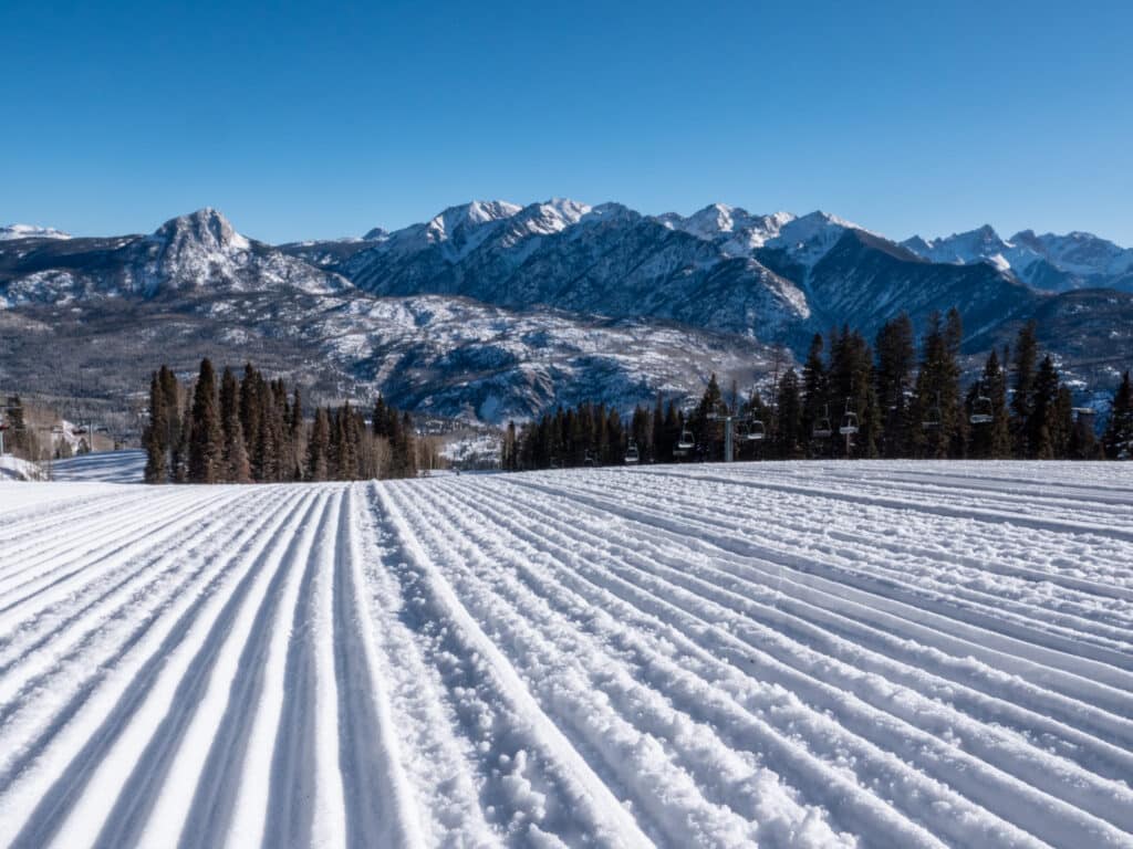 Freshly groomed snow awaits skiers on a lovely bluebird day