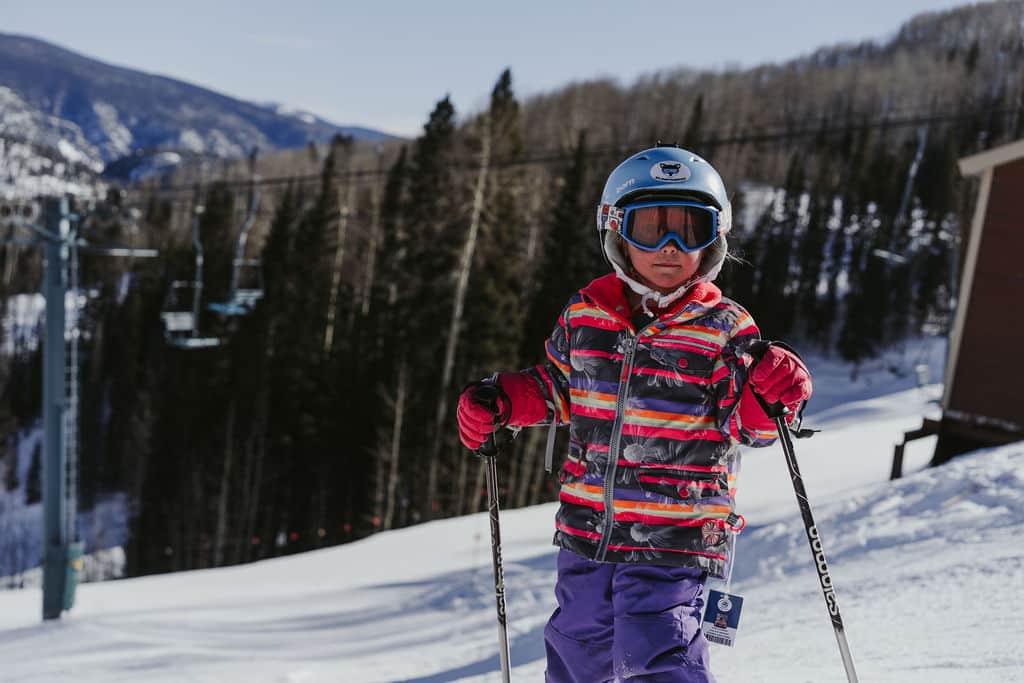 Young girl stands ready to ski down the mountain