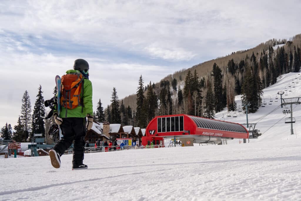 Lift operations employee heads to the chairlift for work