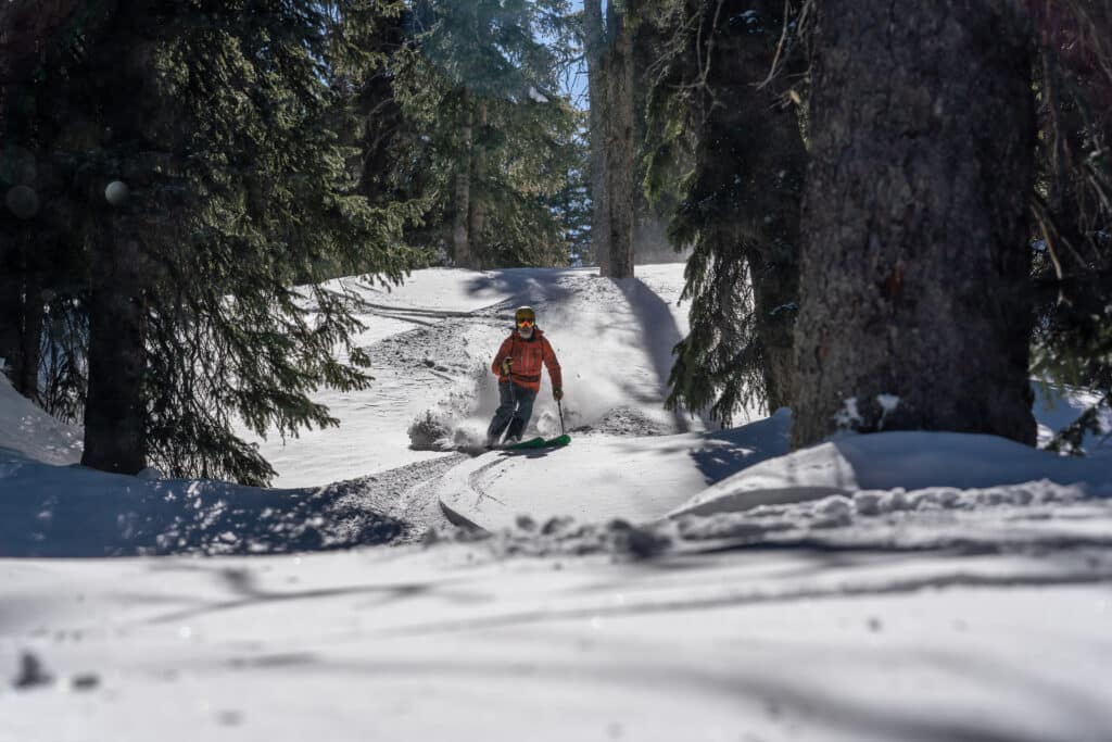 A man skis through a forest