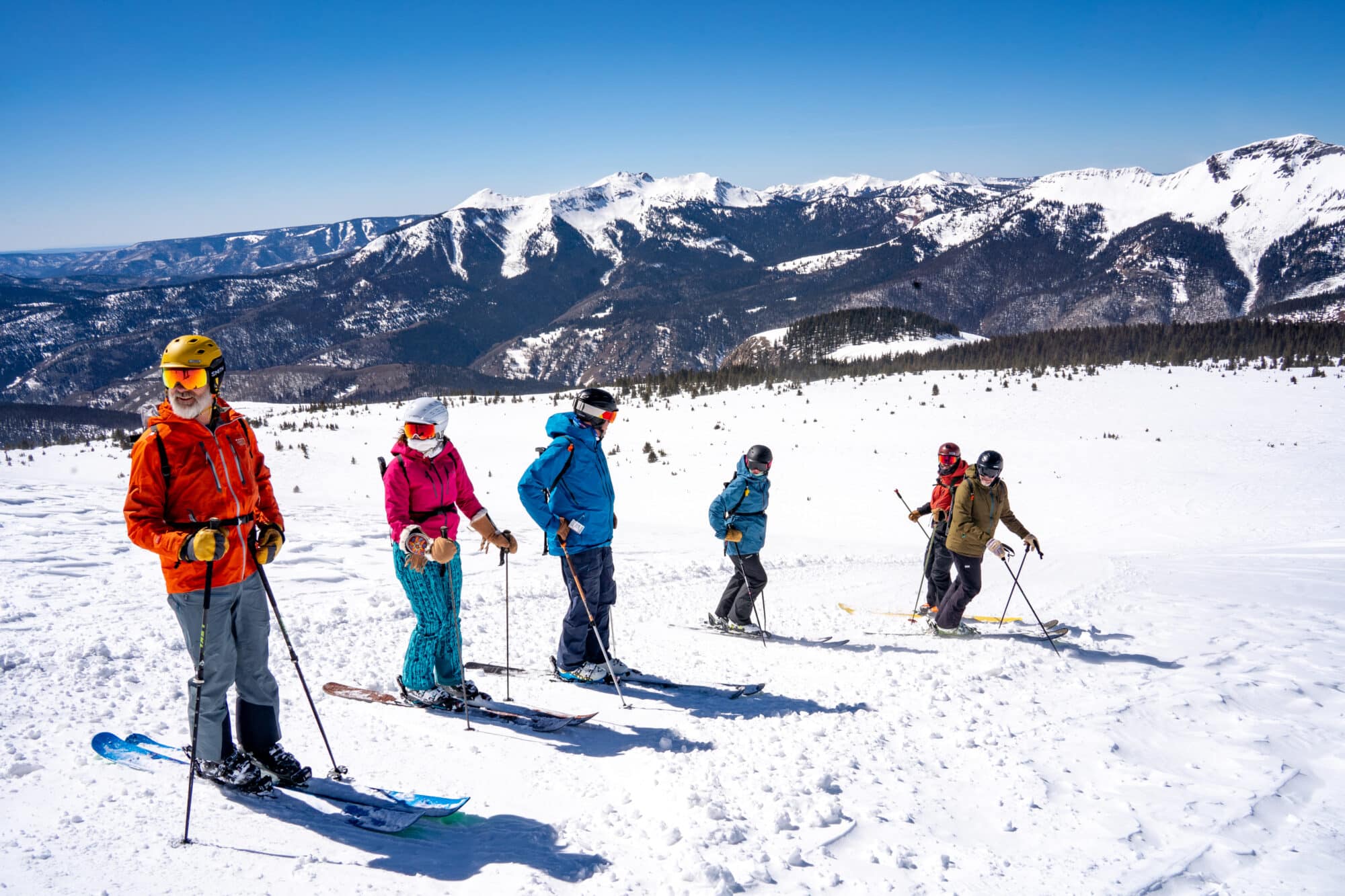 Snowcat skiing group gathers before advancing down the next pitch