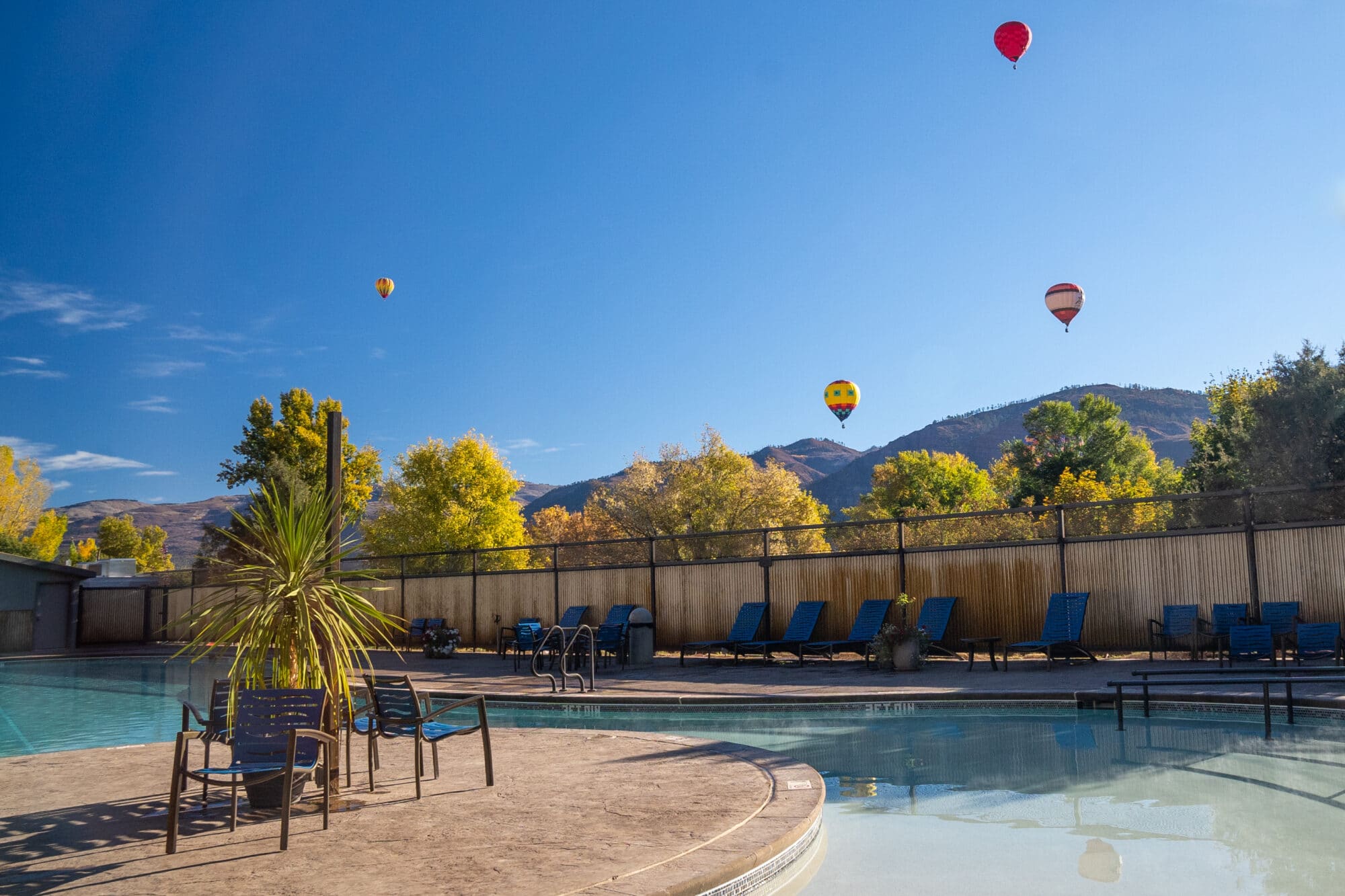 Hot air balloons rise in the distance as viewed from the pools at Durango Hot Springs Resort